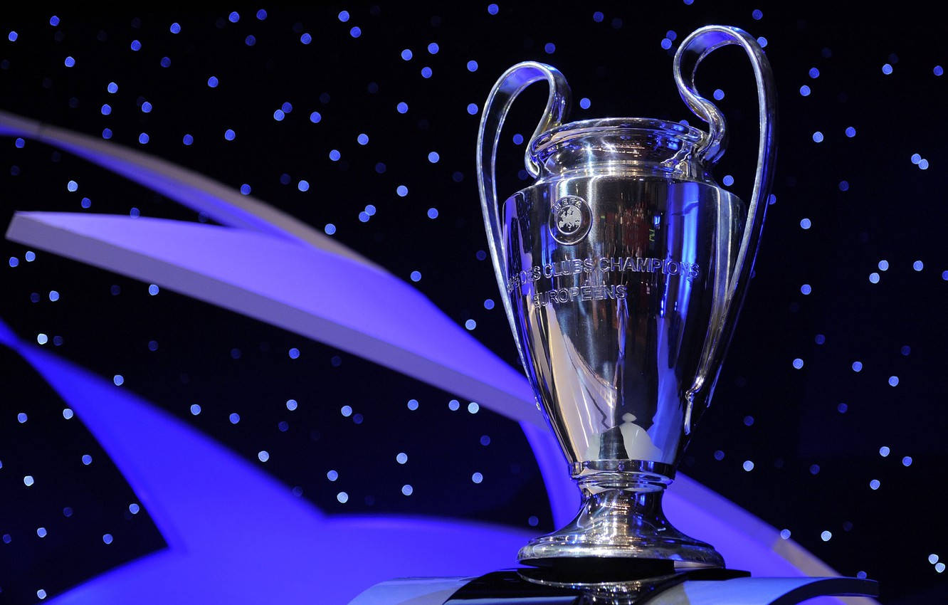 Champions League 桌布 壁紙 — 閃亮的銀色歐冠獎盃在藍色燈光下，以星空背景和抽象紫色形狀襯托下閃爍。