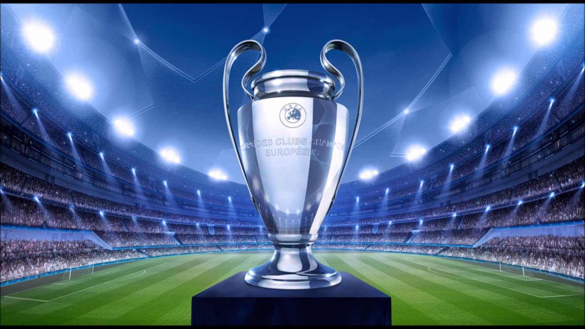 Uefa 桌布 壁紙 — 閃亮的銀色歐洲冠軍聯賽獎盃置於球場中央，在球場燈光下，看台上歡呼的人群。