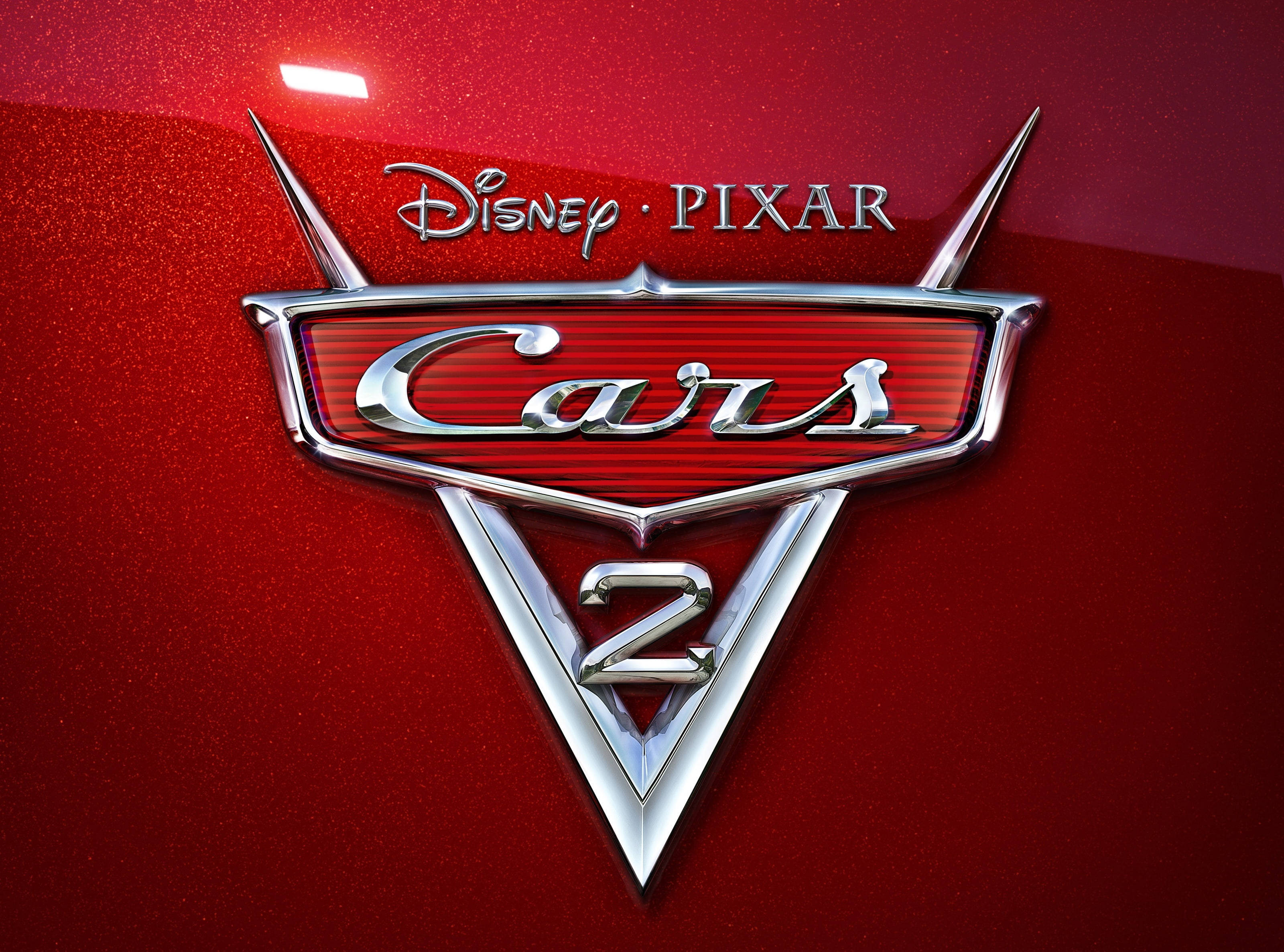 cars 桌布 壁紙 — 閃亮的鍍鉻Cars 2標誌在明亮的攝影棚燈光下，在帶紋理的紅色汽車引擎蓋上閃耀。