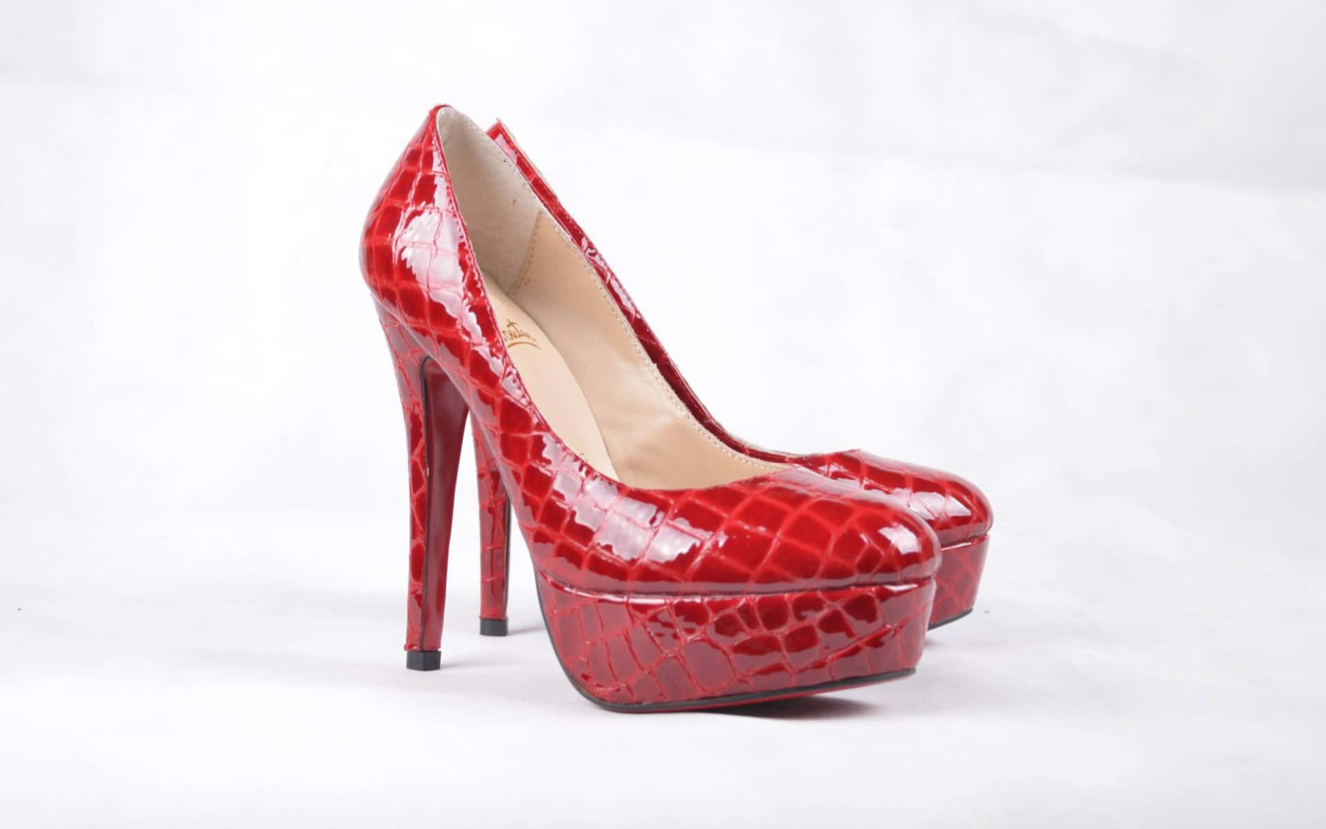 Red High Heels 桌布 壁紙 — 閃亮紅色鱷魚紋厚底高跟鞋，搭配細高跟，置於純白背景上。