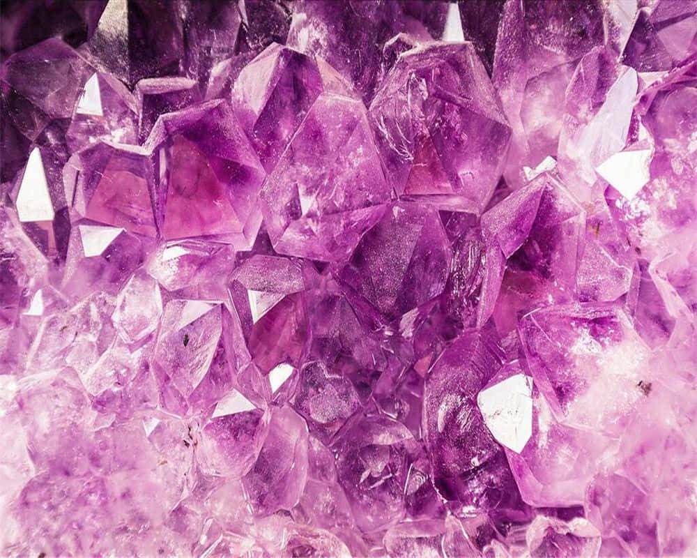 紫水晶 桌布 壁紙 — 閃亮紫色紫水晶晶體的近距離特寫，具有銳利的切面和發光的半透明感。