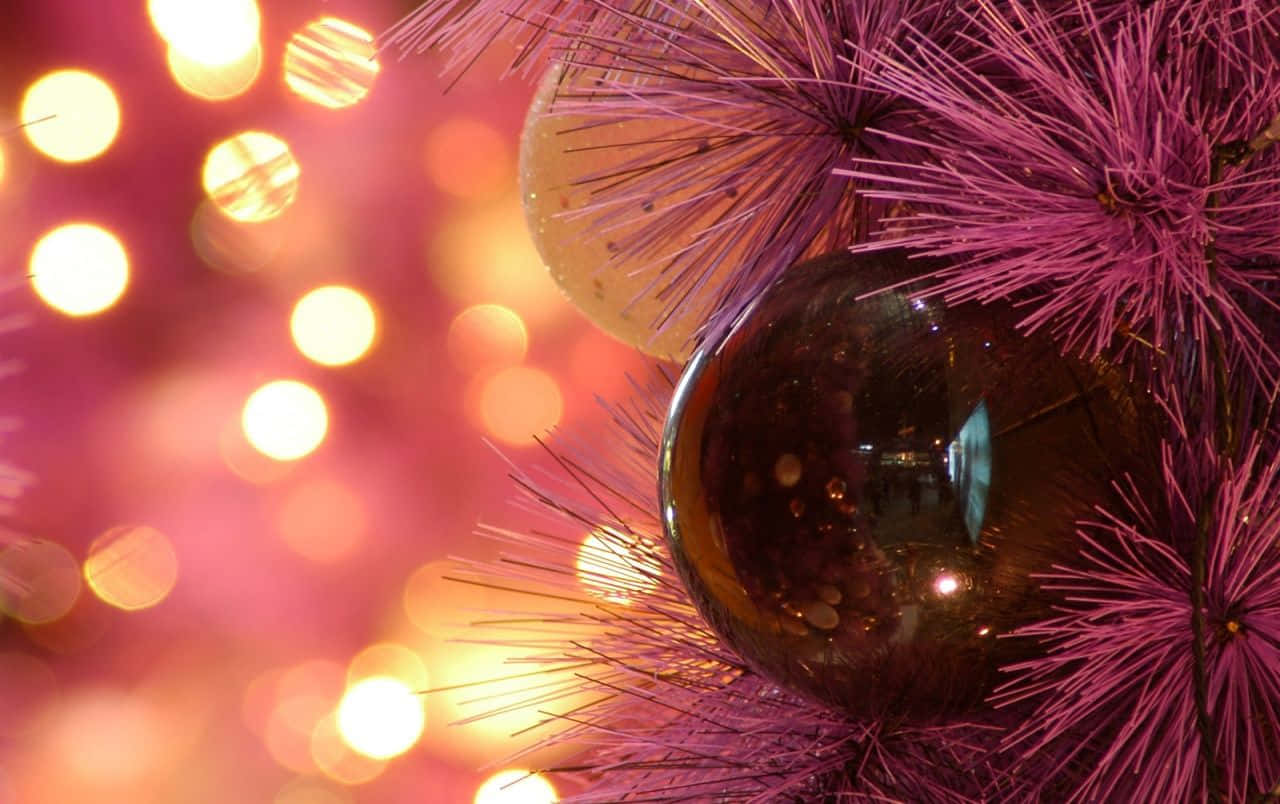 Christmas Ornament 桌布 壁紙 — 閃亮紫色聖誕裝飾品的特寫，鑲嵌在充滿活力的粉紅色金屬絲中，背景中溫暖的金色散景燈光柔和地發光。