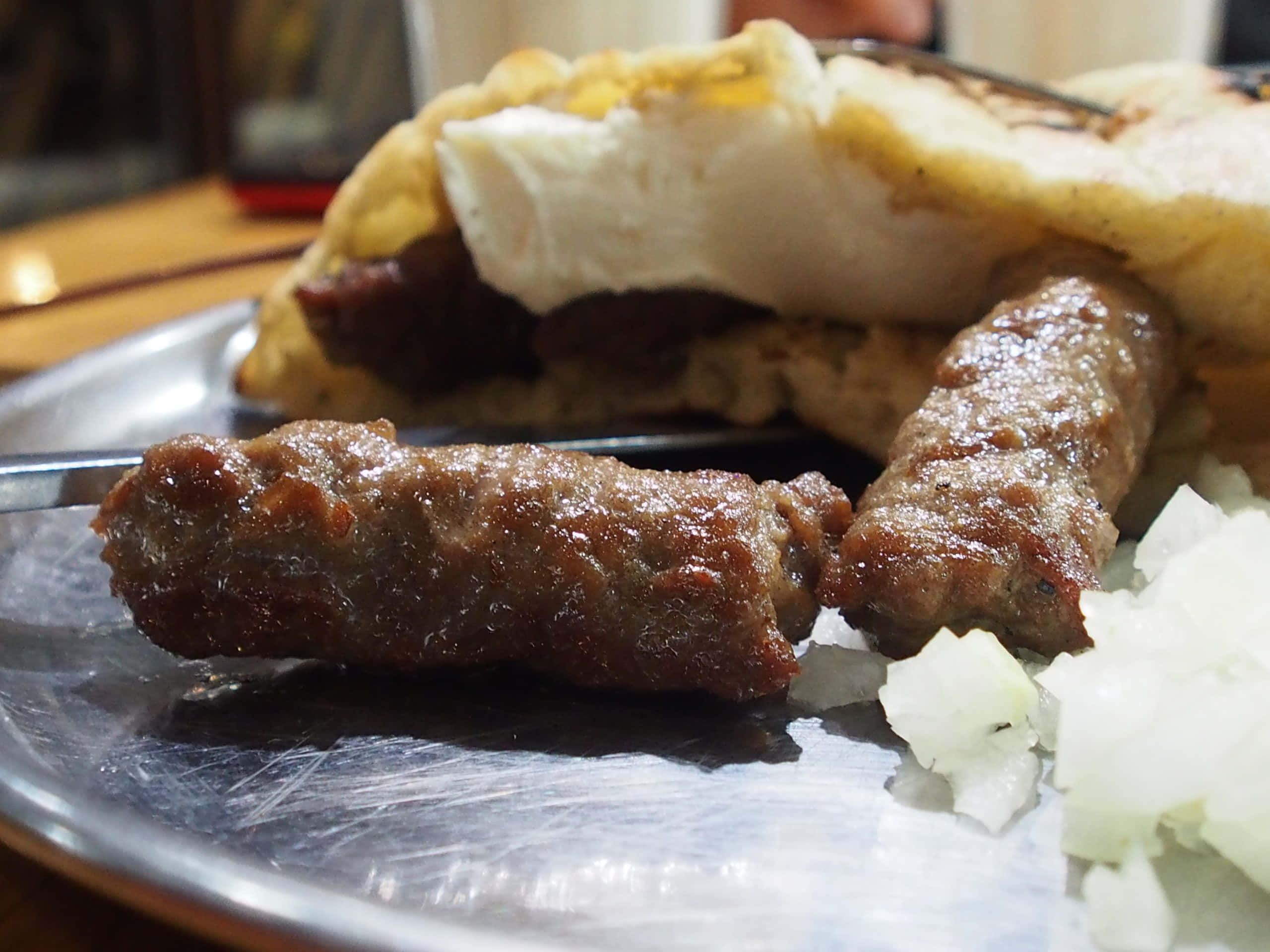 meat 桌布 壁紙 — 閃亮金屬盤上烤香腸和起司麵包卷的特寫。
