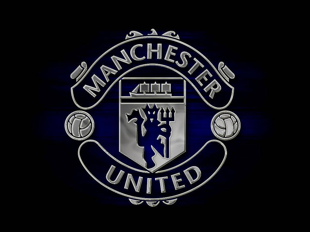 Manchester United Logo 桌布 壁紙 — 閃亮金屬質感的曼聯隊徽，在深藍色漸變背景上發光。