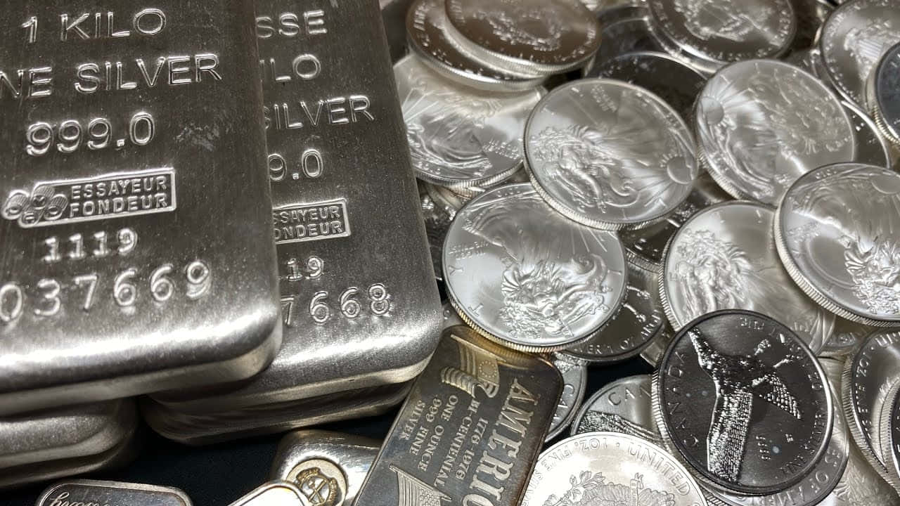 Silver 桌布 壁紙 — 閃亮銀條和銀幣堆疊在一起的近距離特寫，帶有雕刻細節和反光表面。