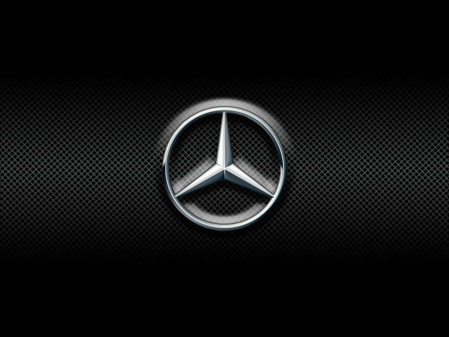Mercedes Benz Logo 桌布 壁紙 — 閃亮銀色 Mercedes-Benz 標誌居中於深色紋理格柵上，帶有微妙燈光效果。