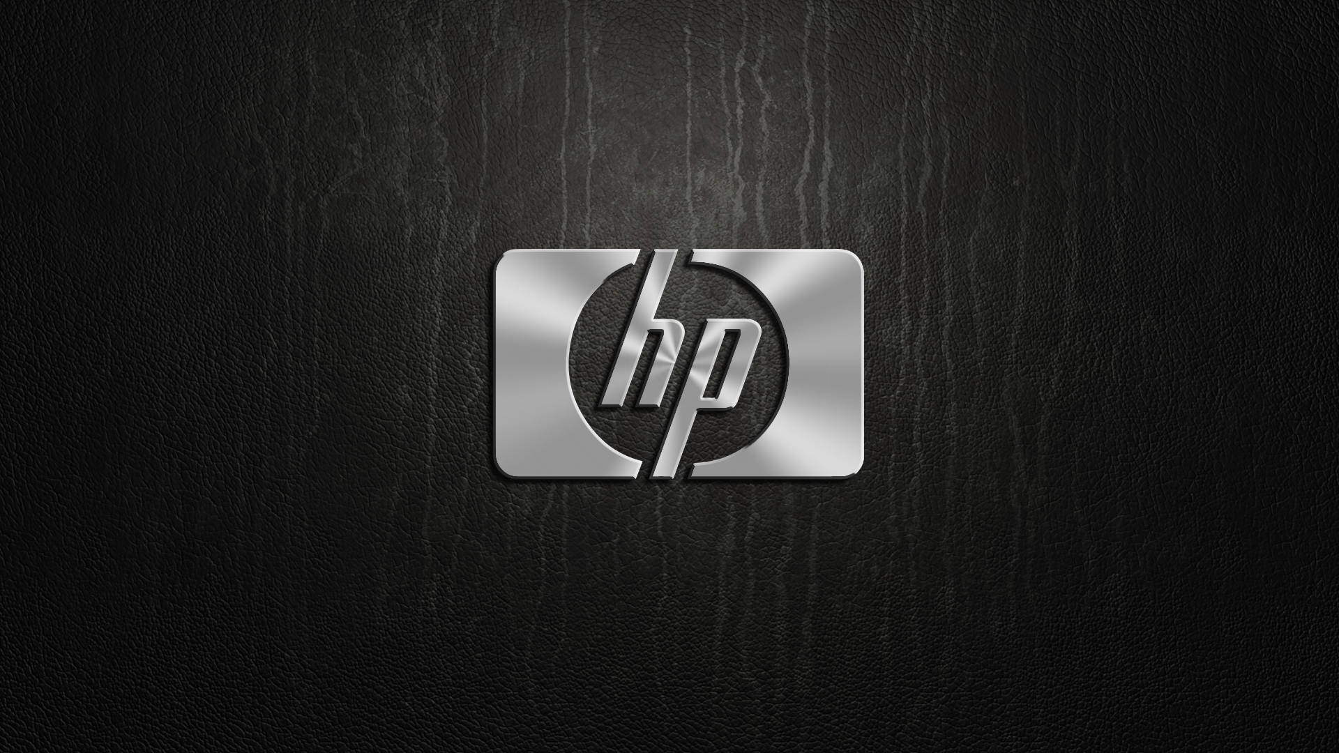 Hp Laptop 桌布 壁紙 — 閃亮銀色HP標誌居中於紋理黑色皮革背景上，帶有柔和燈光。