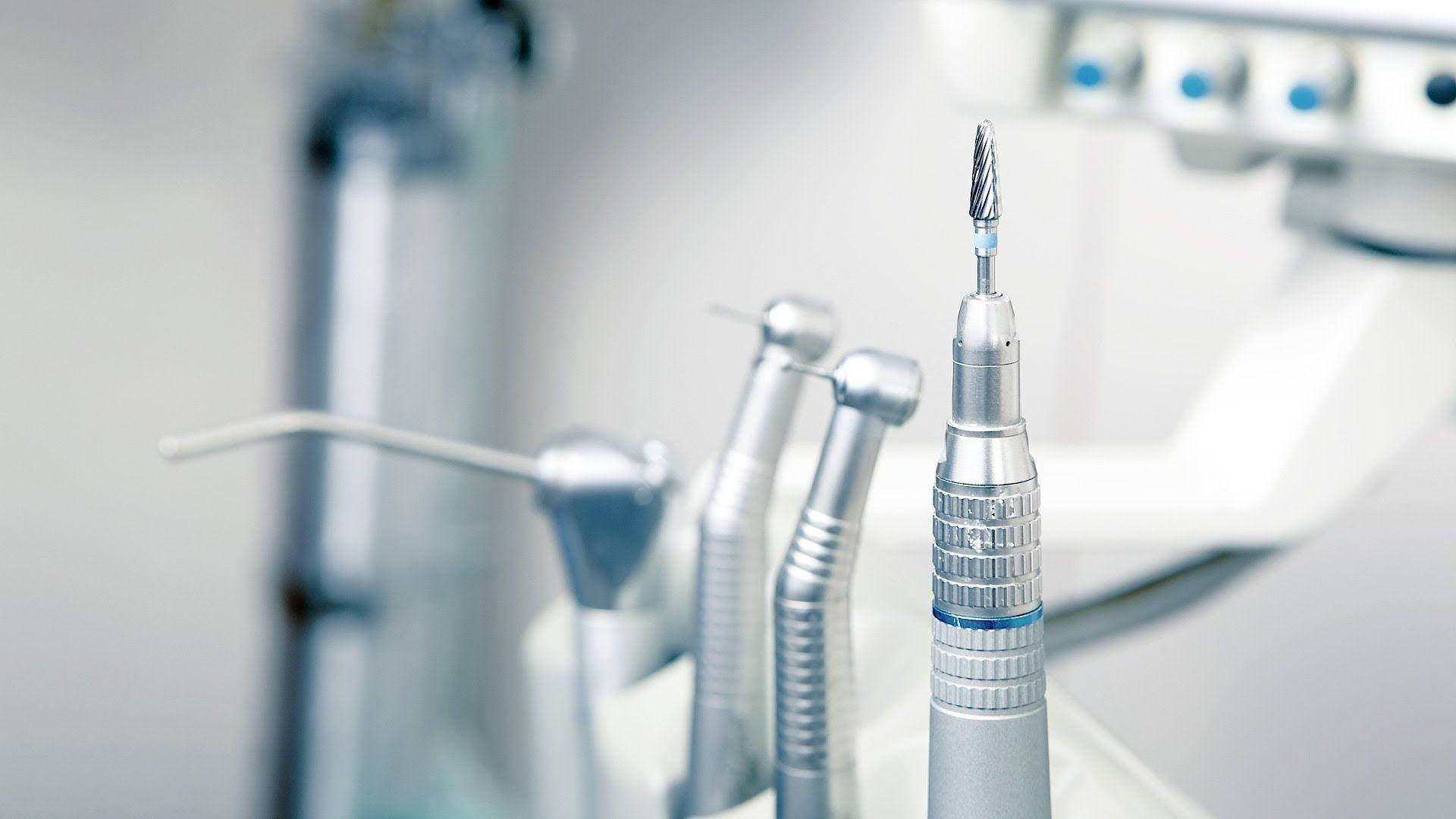 Dentistry 桌布 壁紙 — 閃亮銀色牙科工具的特寫，排列在無菌臨床環境中，背景柔和模糊。