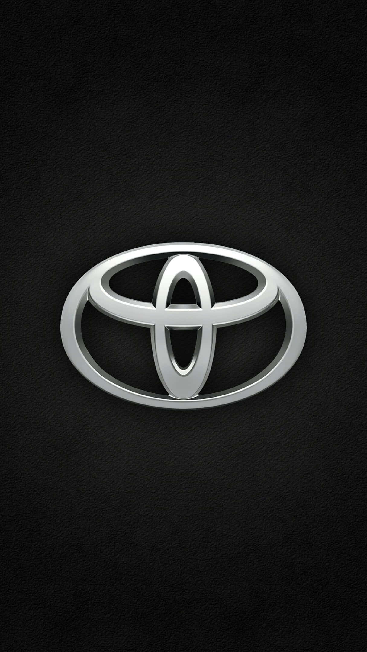Toyota 桌布 壁紙 — 閃亮銀色豐田標誌居中於帶紋理的黑色皮革背景上。