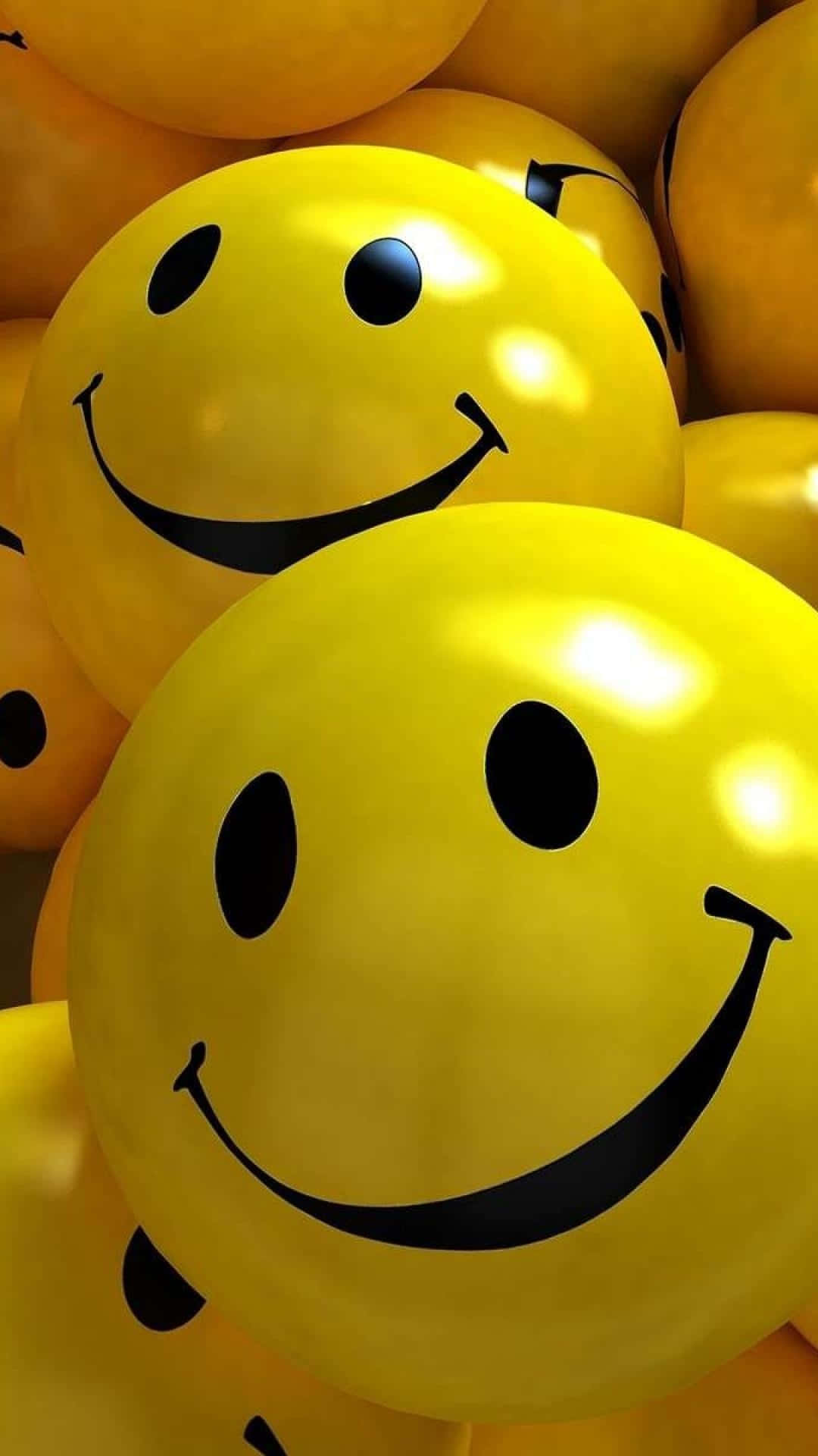 Happy iPhone 桌布 壁紙 — 閃亮黃色氣球帶黑色笑臉聚集在一起的近距離特寫。