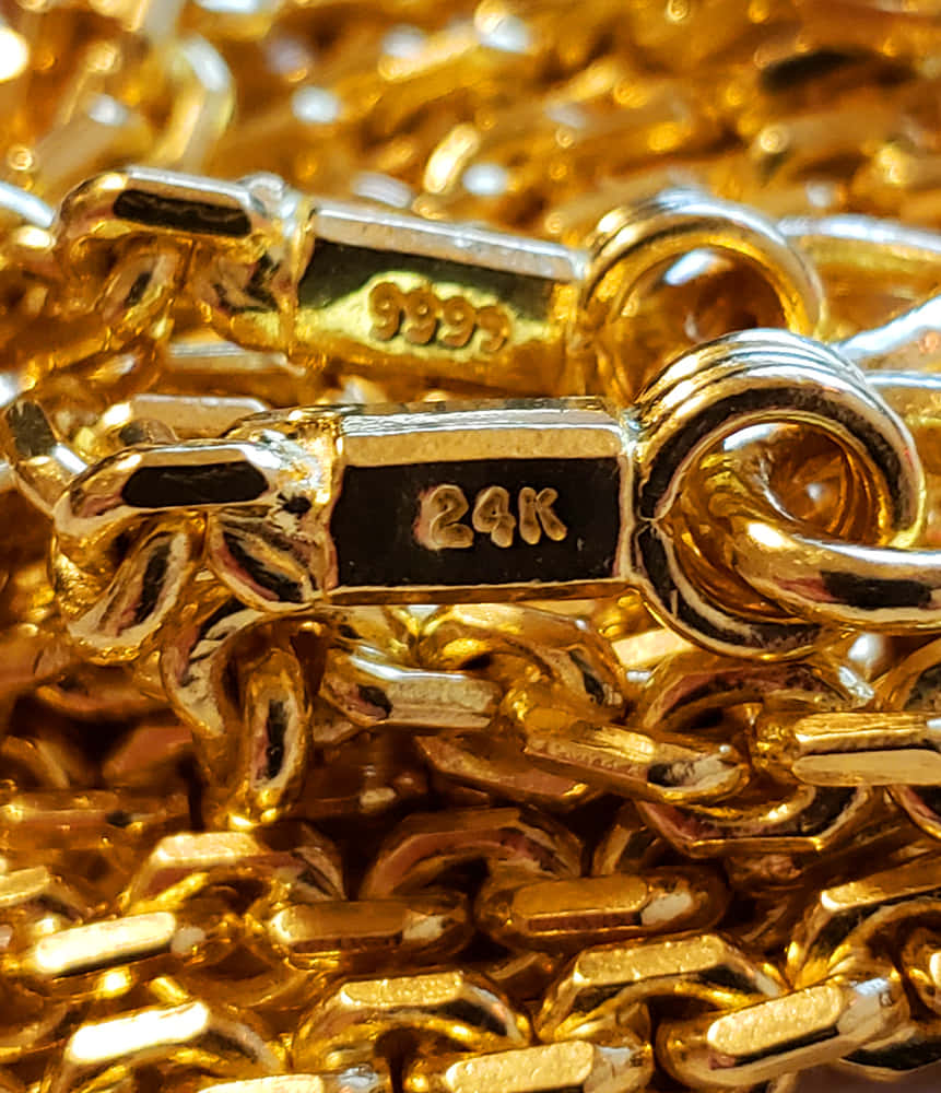 桌布 壁紙 — 閃爍的24K金鏈特寫，帶有刻印的純度標記，堆疊在奢華的金色鏈環中。