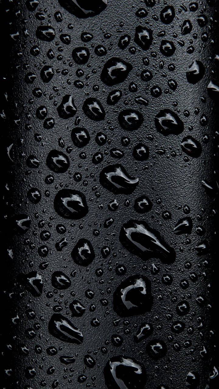 Droplets 桌布 壁紙 — 閃爍的水滴依附在啞光黑色紋理表面上，營造出陰鬱的抽象圖案。