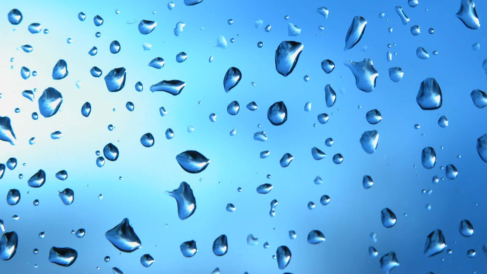 水 桌布 壁紙 — 閃爍的水珠依附在玻璃表面，背景是寧靜的漸變藍天。