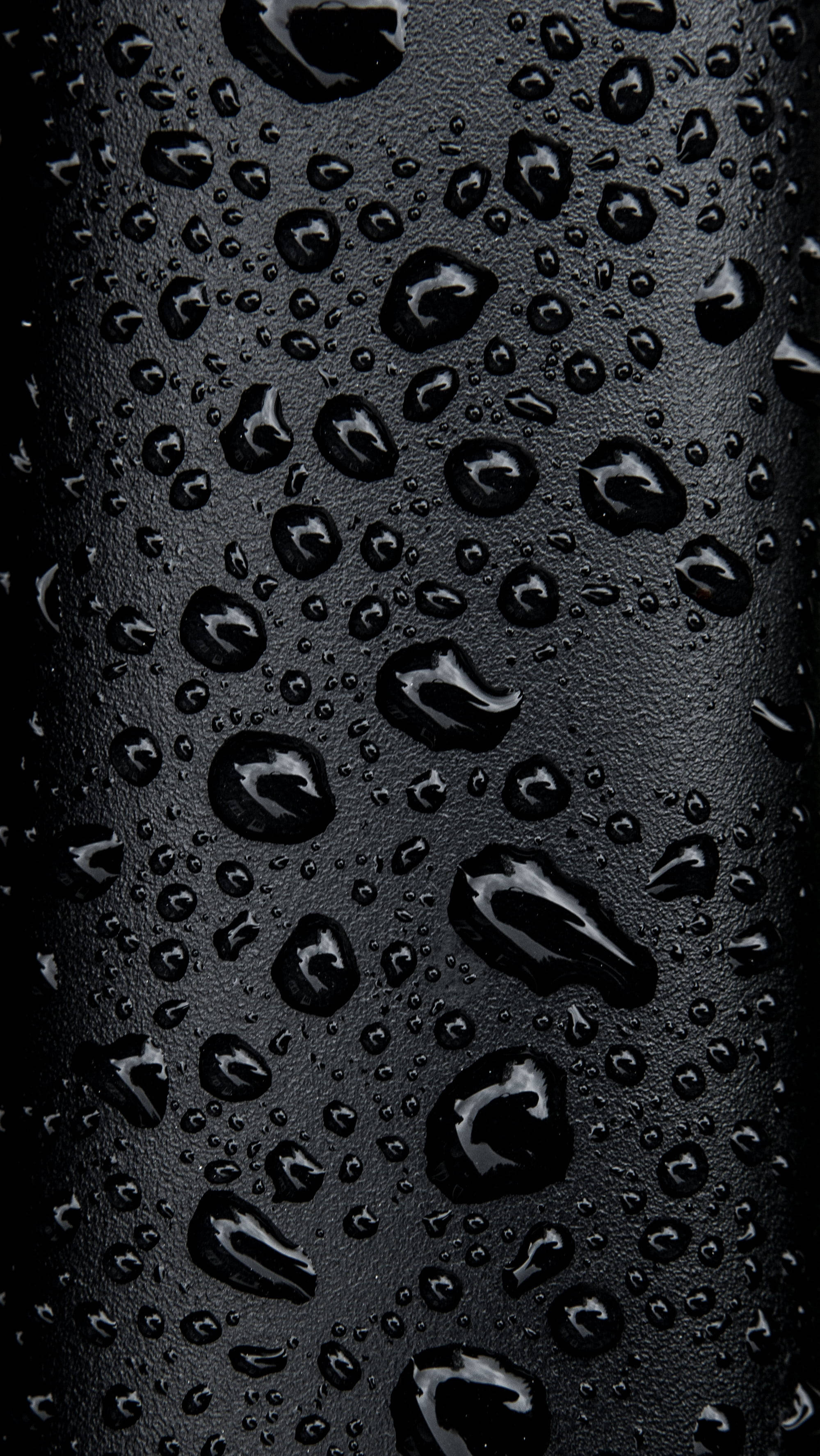 Most Beautiful Rain 桌布 壁紙 — 閃爍的水珠依附在霧面黑色紋理表面上，營造出陰鬱的抽象特寫。
