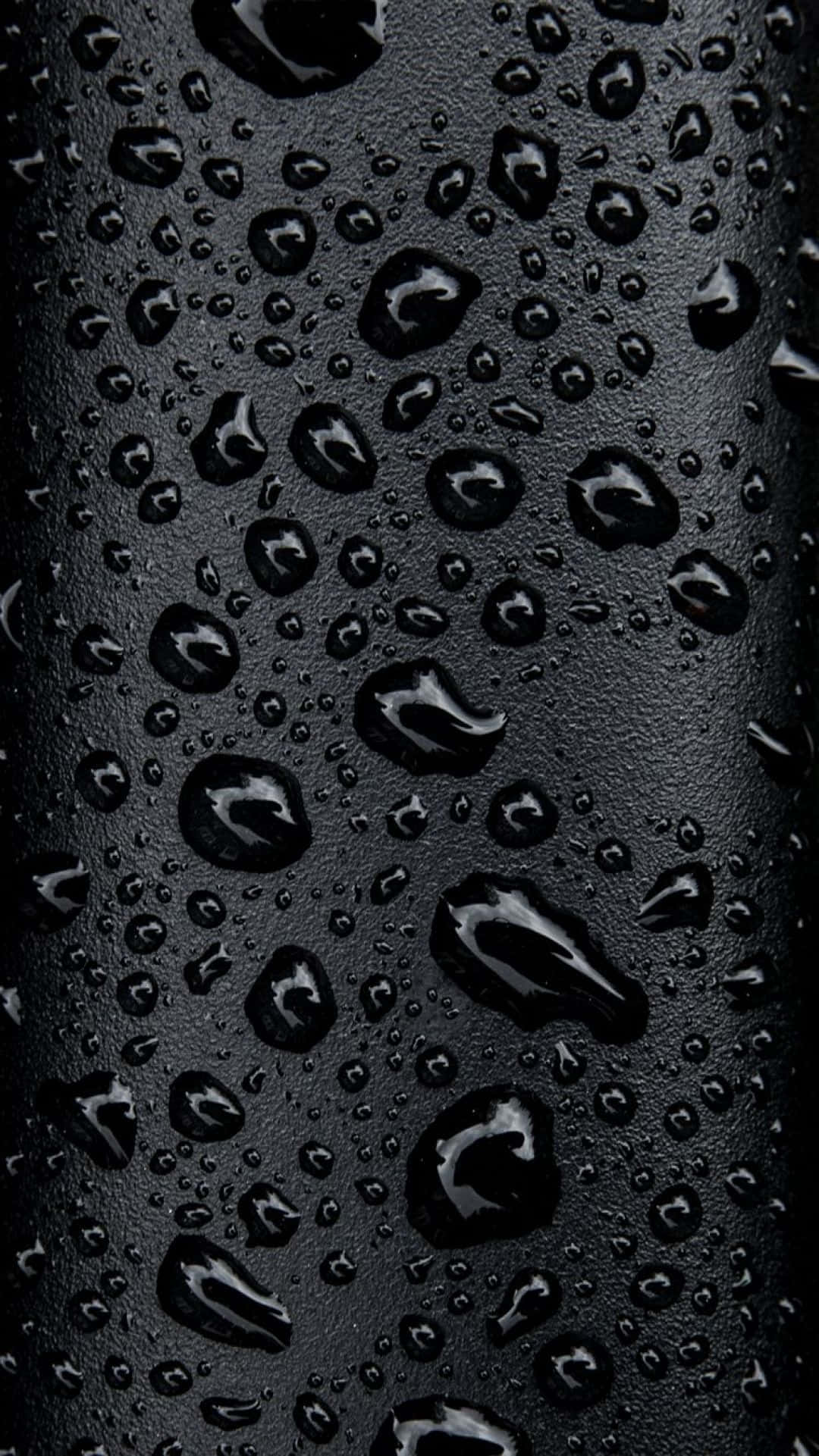 黑色 iPhone 桌布 桌布 壁紙 — 閃爍的水珠依附在霧面黑色紋理表面上，形成高對比度的微距拍攝。