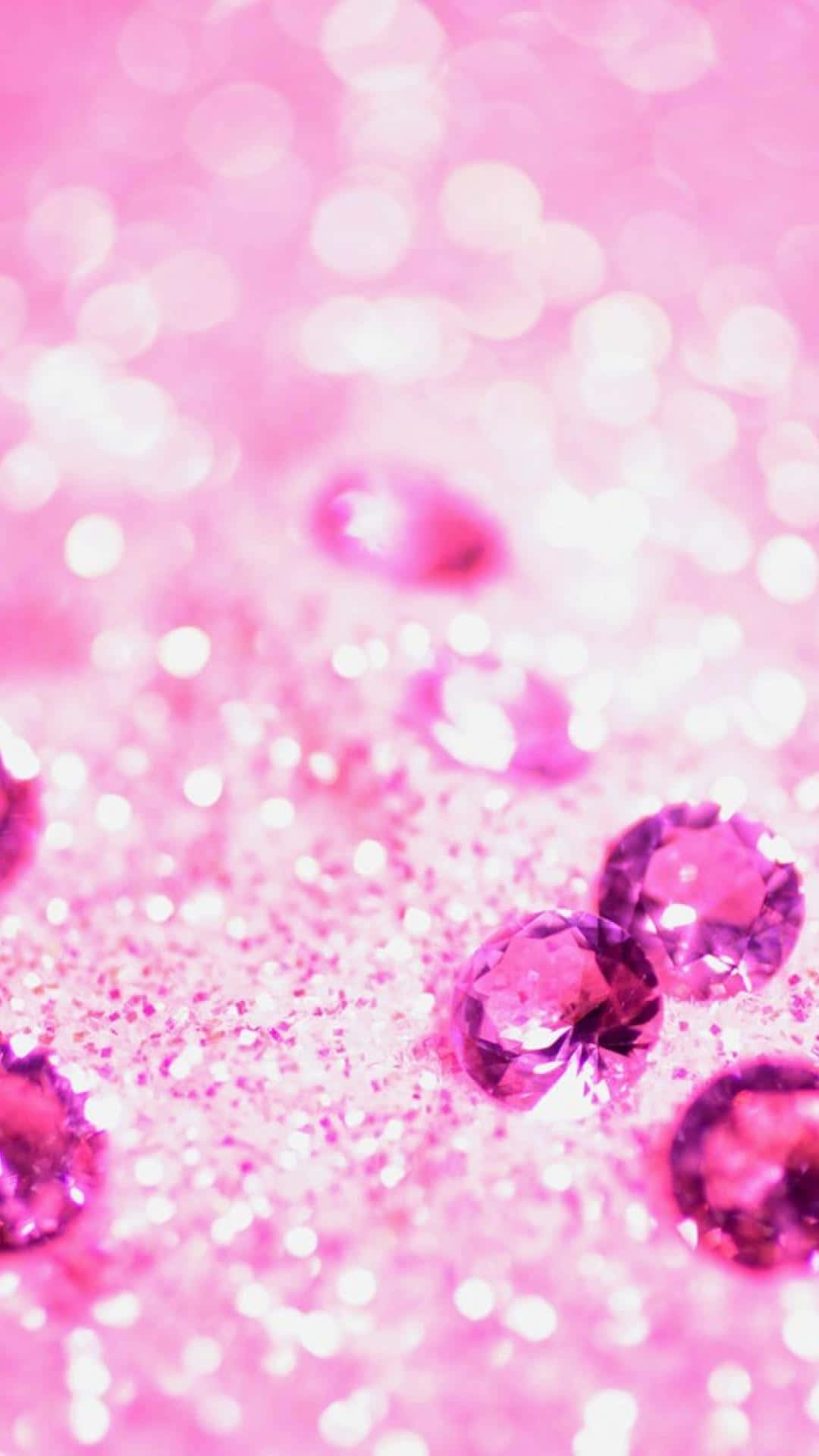 Pink Girly 桌布 壁紙 — 閃爍的粉紅閃粉圍繞著多面切割的紫色寶石，背景帶有柔和散景燈光。