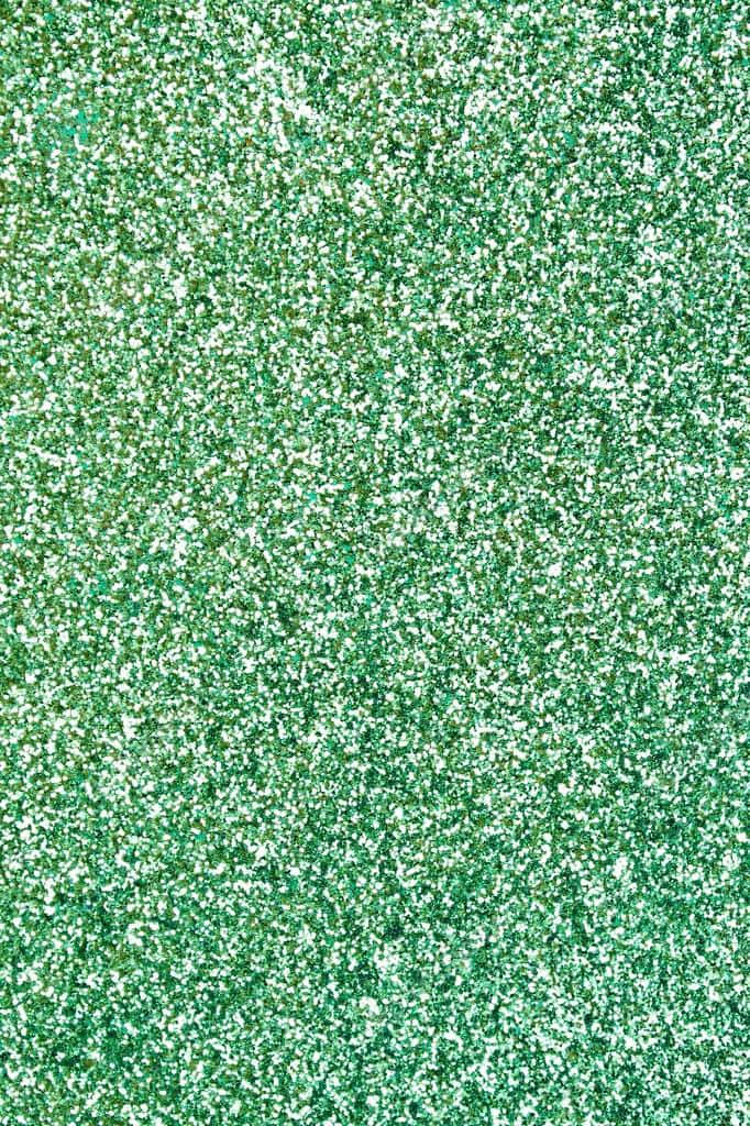 Green Glitter 桌布 壁紙 — 閃爍的綠色亮片質感，帶有白色斑點，營造出閃亮的抽象表面。