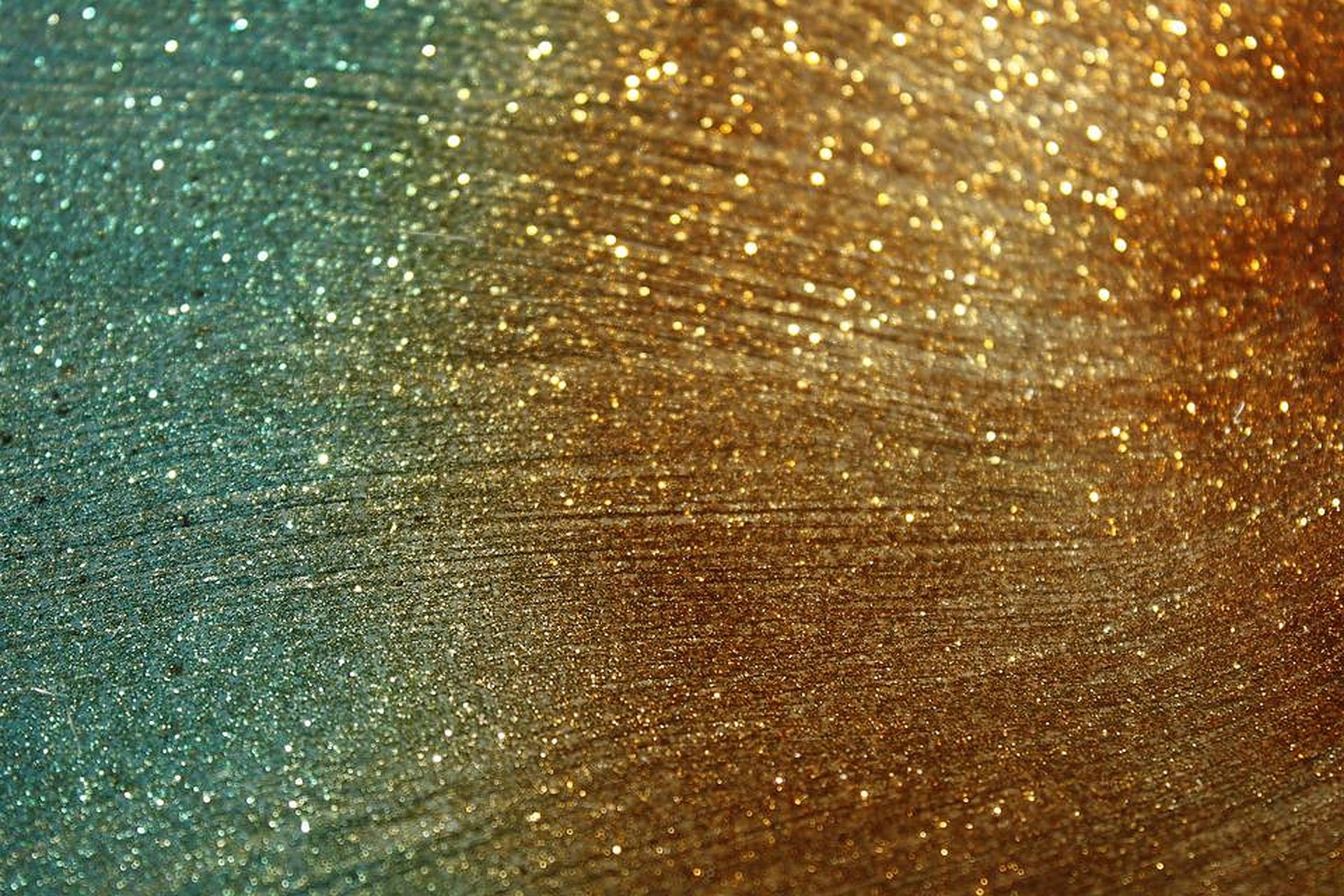 Dust 桌布 壁紙 — 閃爍的藍綠色和金色亮粉漸變，帶有精細的筆觸紋理，營造出奢華閃亮的效果。
