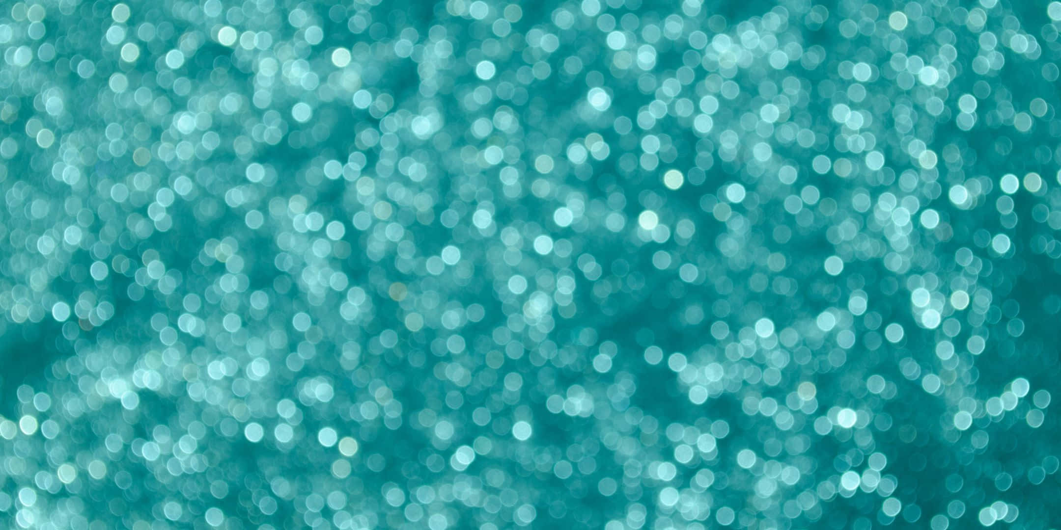 Teal Glitter 桌布 壁紙 — 閃爍的藍綠色背景，充滿柔和失焦的圓形散景燈光，營造出夢幻閃爍的效果。