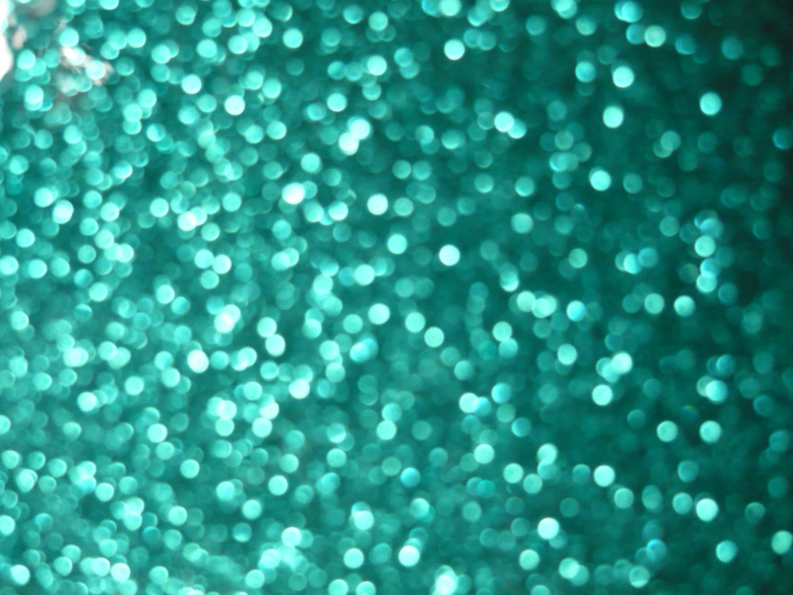 Teal Desktop 桌布 壁紙 — 閃爍的藍綠色閃粉顆粒在柔和散景效果中捕捉光線。