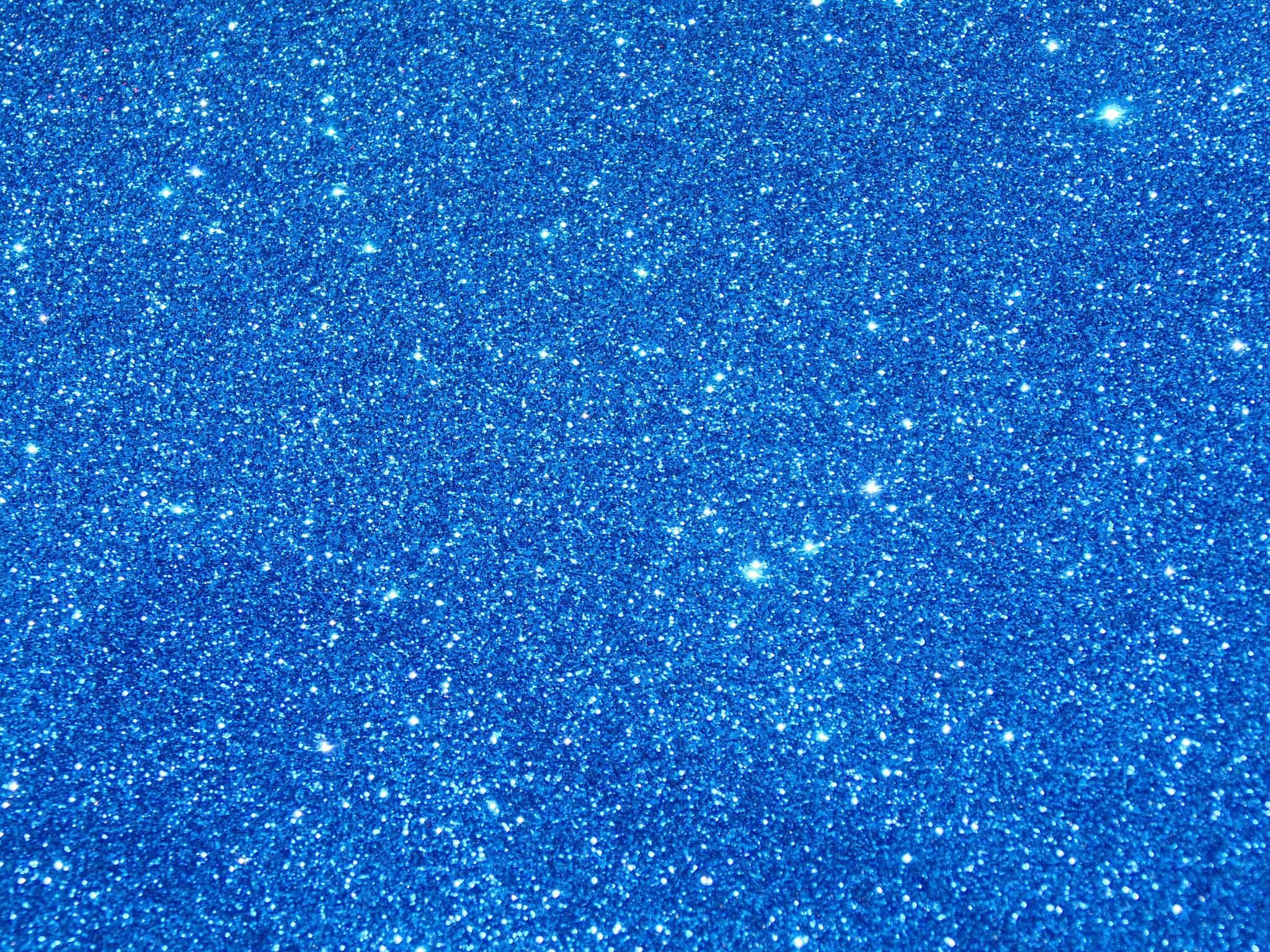 Blue Glitter 桌布 壁紙 — 閃爍的藍色亮片紋理，帶有明亮的白色斑點，在表面上捕捉光線。