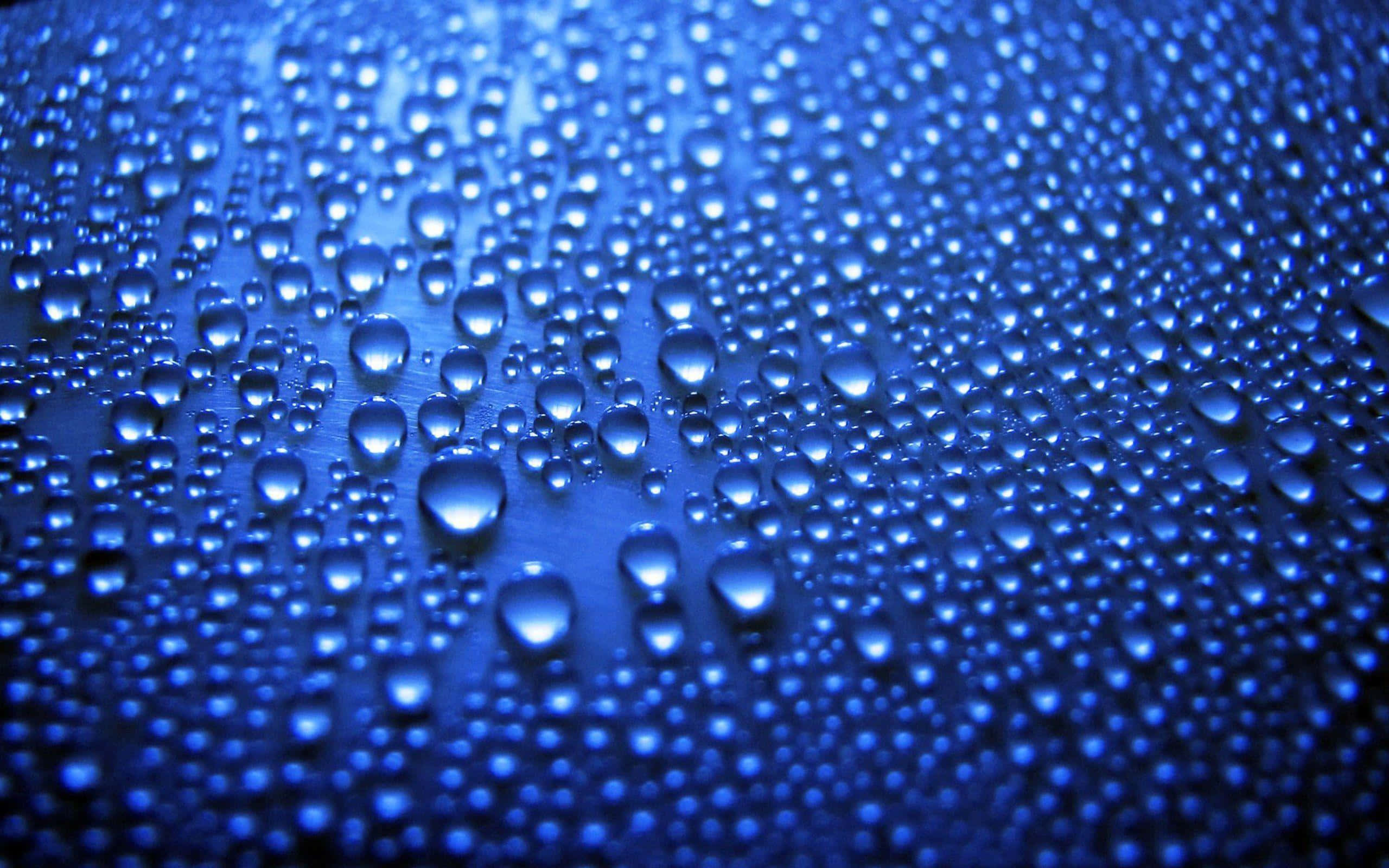 水 桌布 壁紙 — 閃爍的藍色水滴在柔和光線下聚集在光滑表面上，營造出清涼的紋理抽象背景。