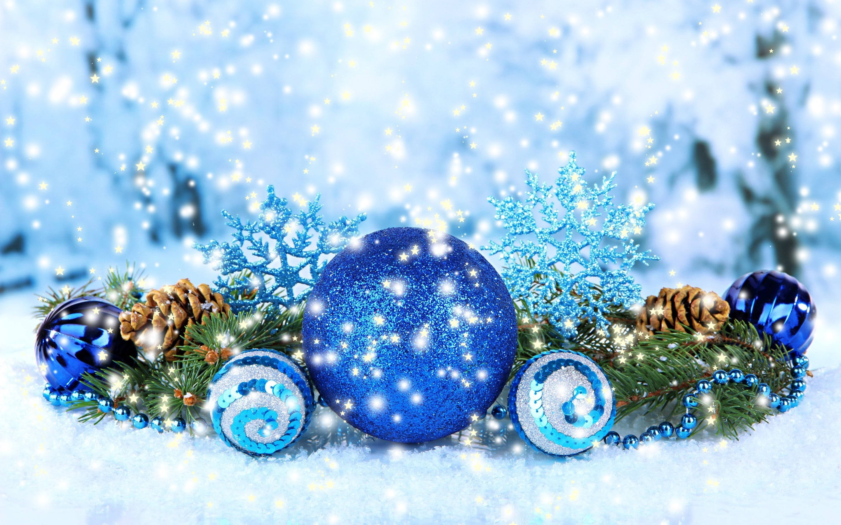 balls 桌布 壁紙 — 閃爍的藍色裝飾品、松果和雪花在雪地上，伴隨著飄落的雪花和發光的燈光。