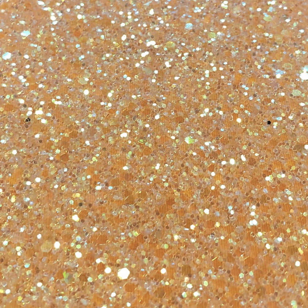 閃爍 桌布 壁紙 — 閃爍的金色和銀色亮片散落在溫暖的橙色紋理表面上的特寫。