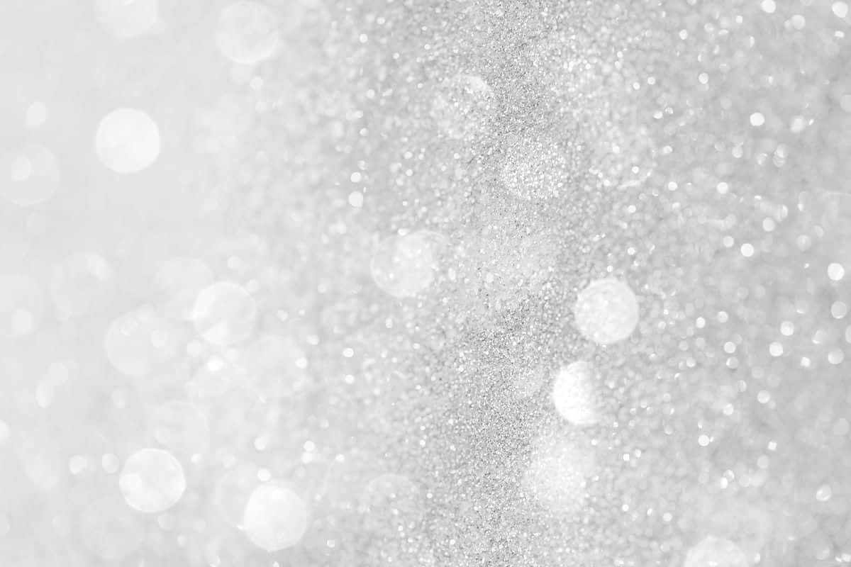 White Glitter 桌布 壁紙 — 閃爍的銀色亮粉紋理，帶有柔和散景圓圈，營造出閃亮的抽象背景。