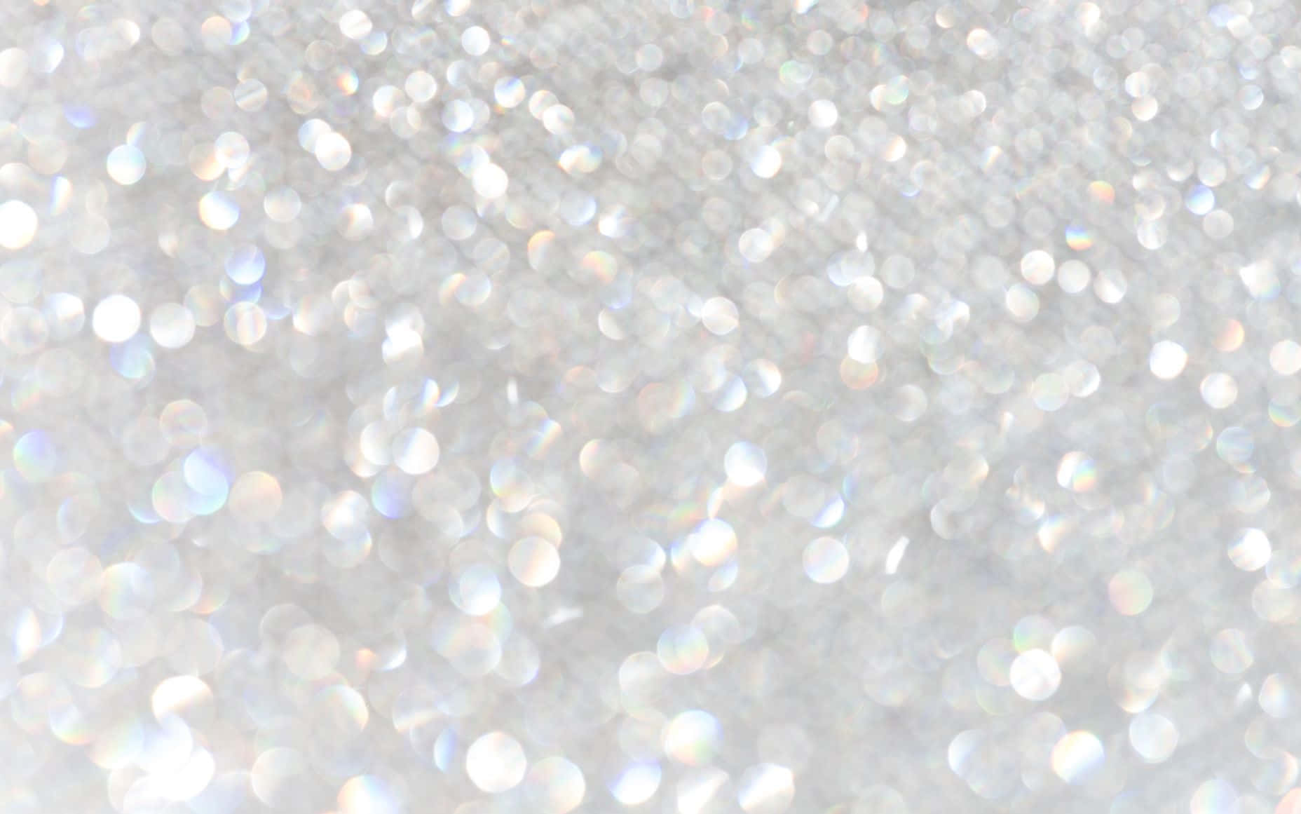 White Glitter 桌布 壁紙 — 閃爍的銀色亮粉顆粒場，捕捉光線並帶有柔和彩虹反射。