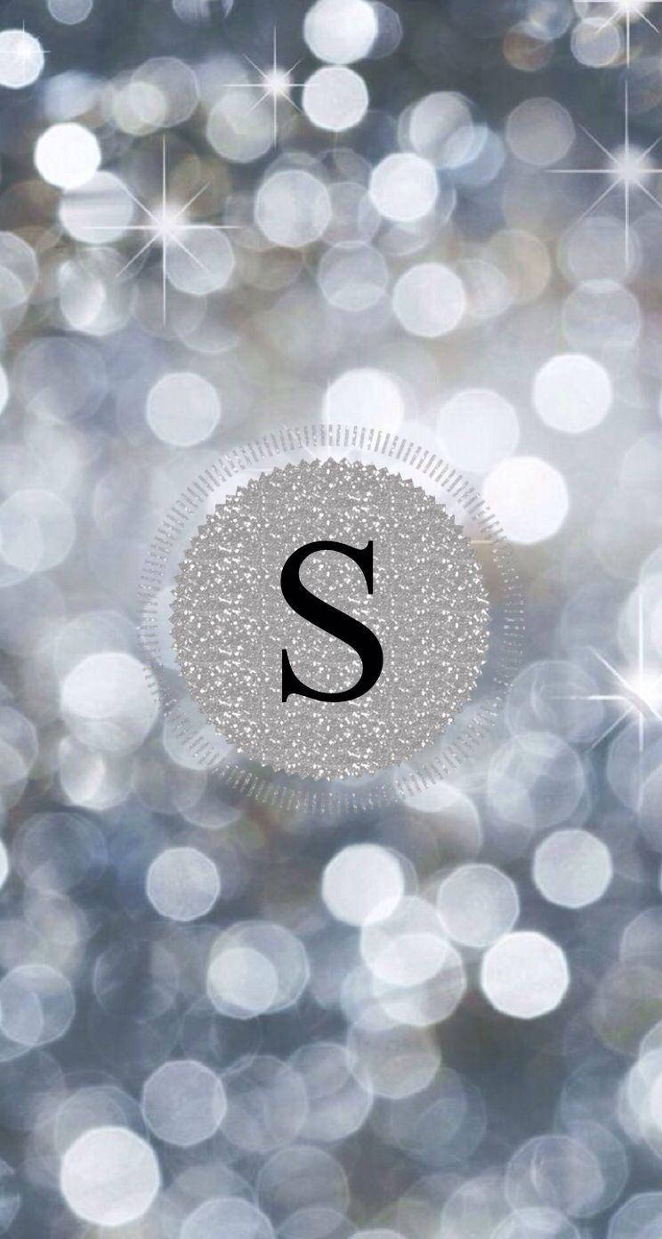 S 桌布 壁紙 — 閃爍的銀色字母組合「S」在散景背景中閃閃發光，背景有閃爍的光圈和星芒。