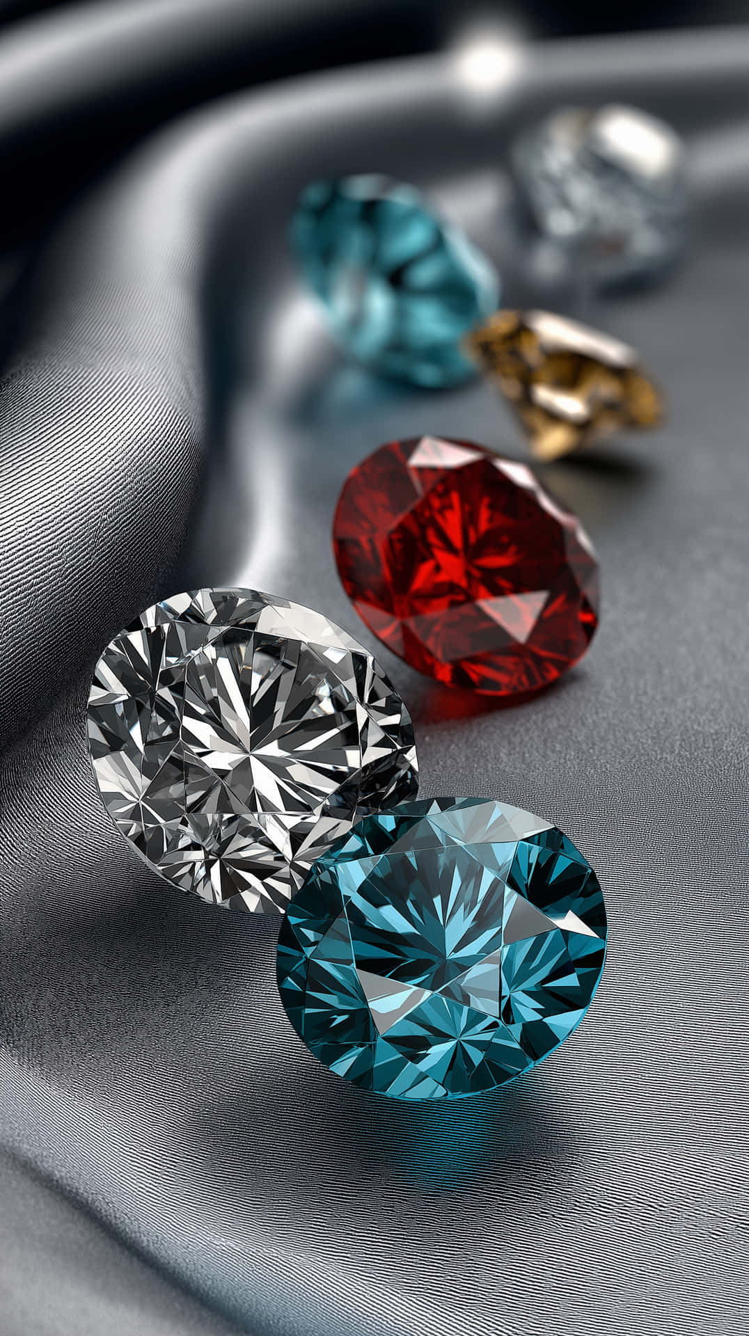 Silken Gem Assortment 壁紙 — 閃爍的鑽石，呈現紅色、藍色和透明色調，靜置在光滑的銀色布料表面上。