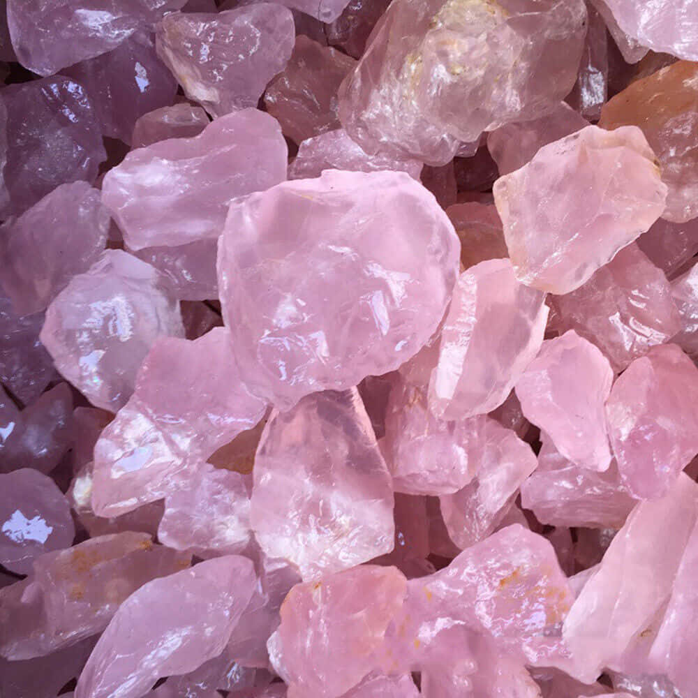 Pink Crystal Quartz 桌布 壁紙 — 閃爍粉紅玫瑰石英晶體的近距離特寫，具有半透明刻面，捕捉柔和光線。