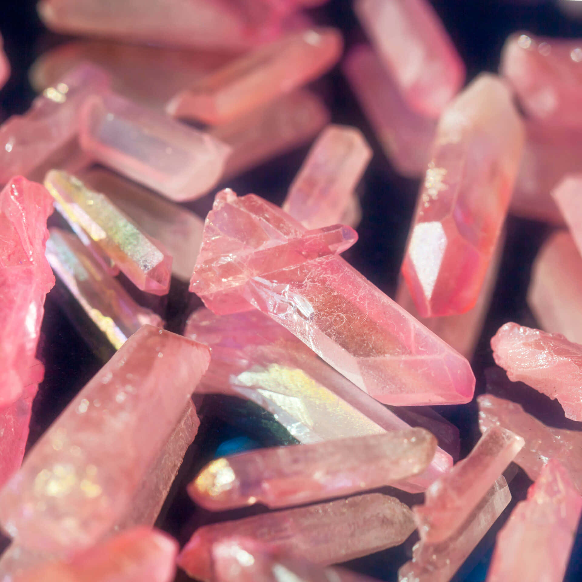 Pink Crystal Quartz 桌布 壁紙 — 閃爍粉紅色水晶碎片在黑暗背景下捕捉光線的特寫。