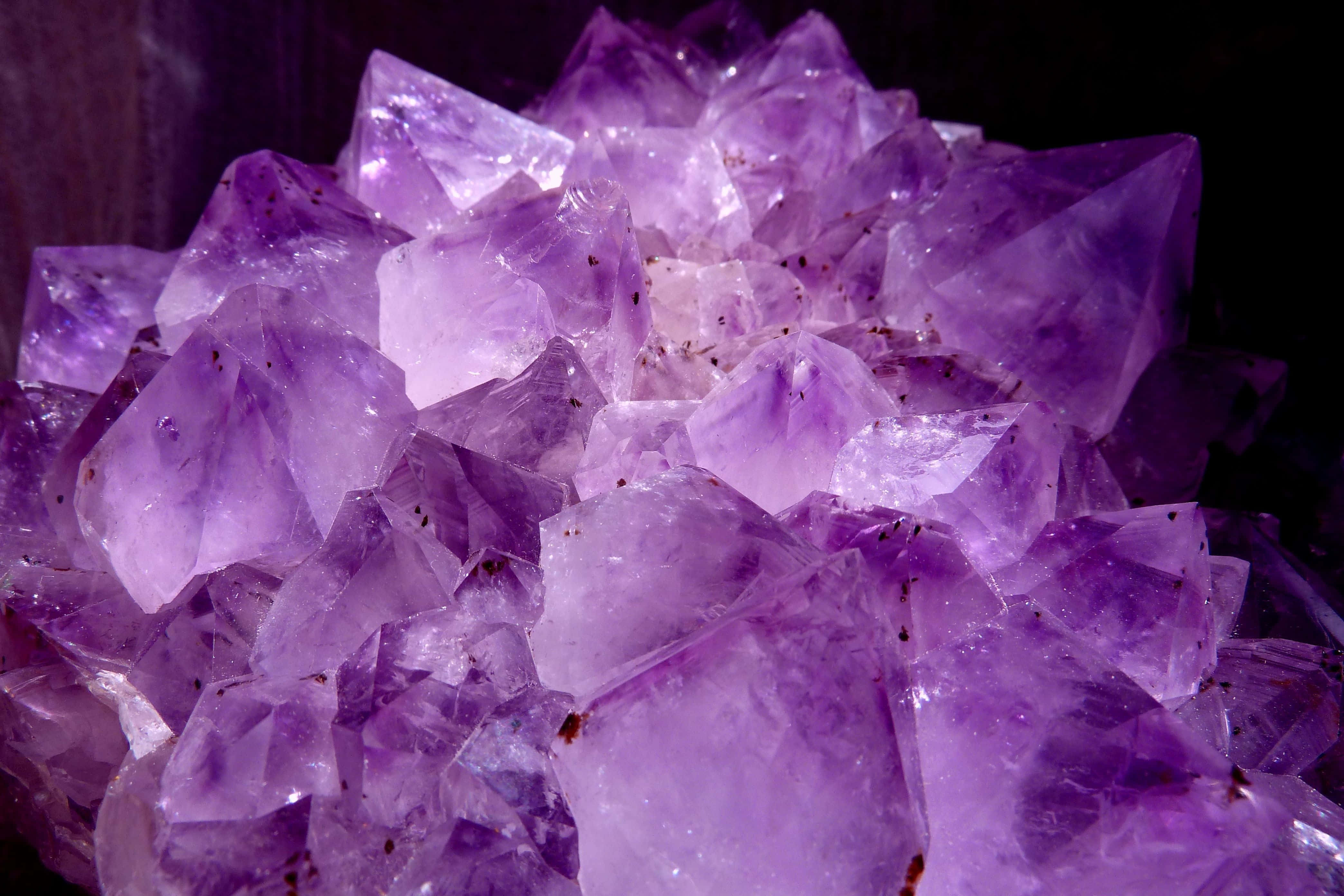 紫水晶 桌布 壁紙 — 閃爍紫色紫水晶晶體在黑暗背景上發光的特寫。