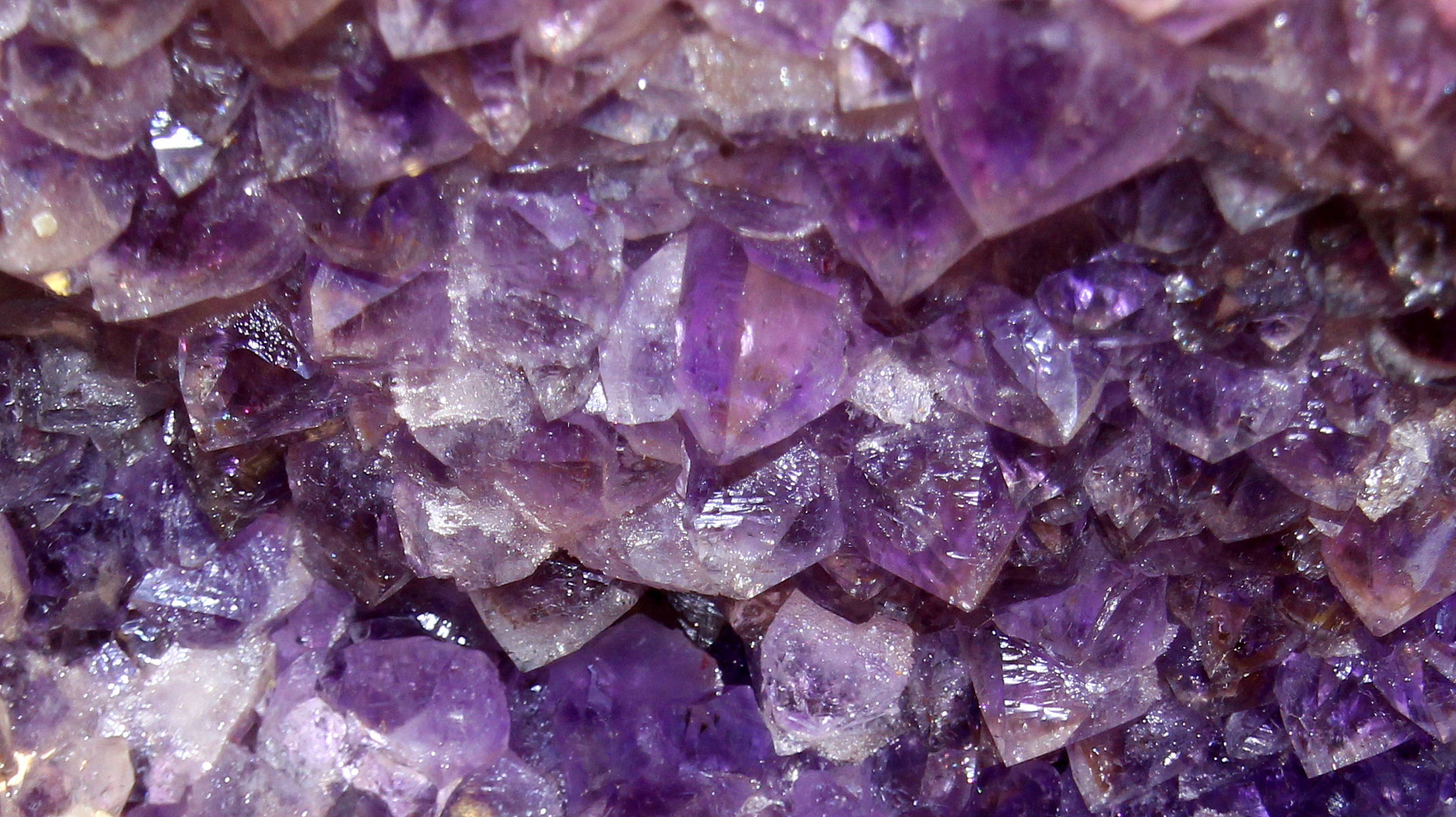紫水晶 桌布 壁紙 — 閃爍紫色紫水晶晶體的近距離特寫，具有銳利的刻面和半透明層，捕捉光線。