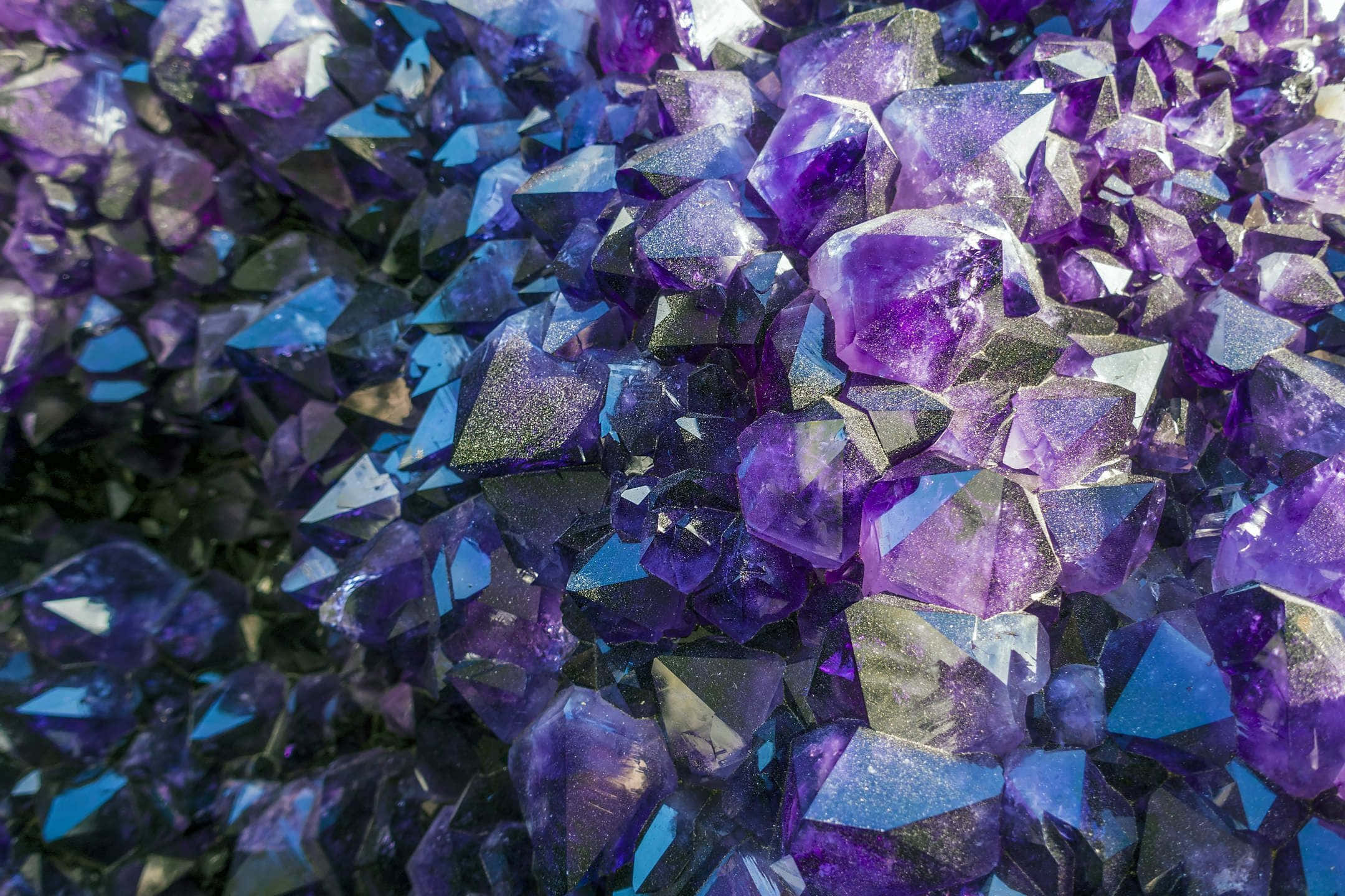 Healing Crystals 桌布 壁紙 — 閃爍紫色紫水晶晶體的近距離特寫，銳利的刻面捕捉豐富色調的光線。
