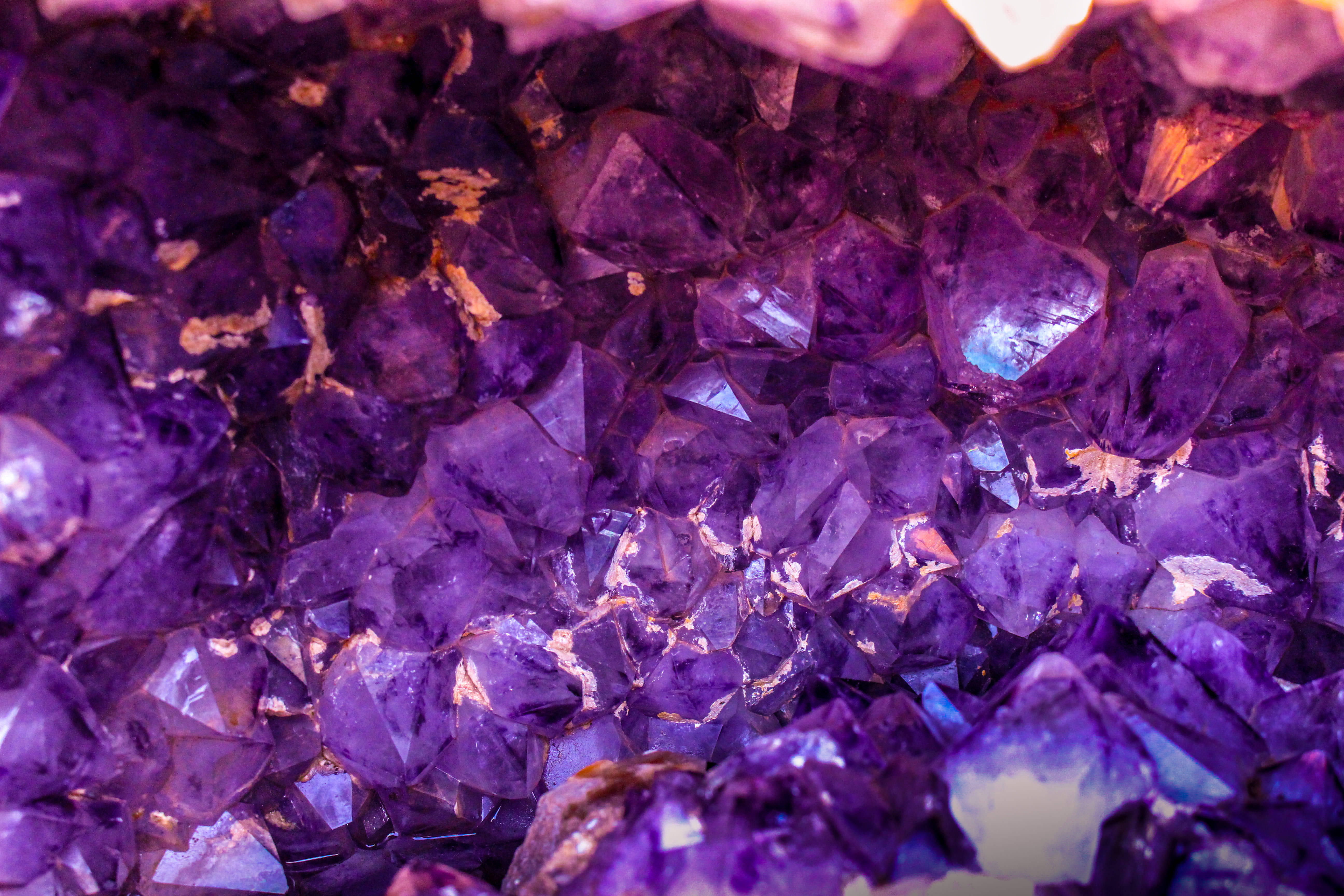 Amethyst 桌布 壁紙 — 閃爍紫色紫水晶晶體的近距離特寫，帶有金色亮點和深紫羅蘭色調。