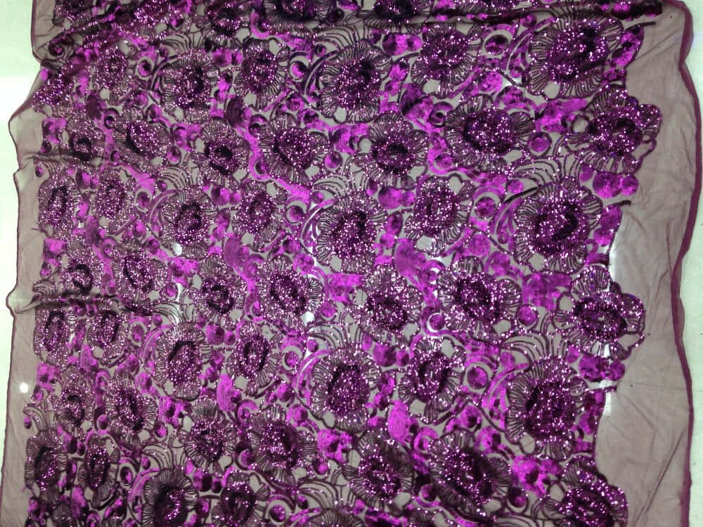 Purple Sequins 桌布 壁紙 — 閃爍紫色蕾絲布料的特寫，帶有複雜的花卉圖案和閃亮裝飾。
