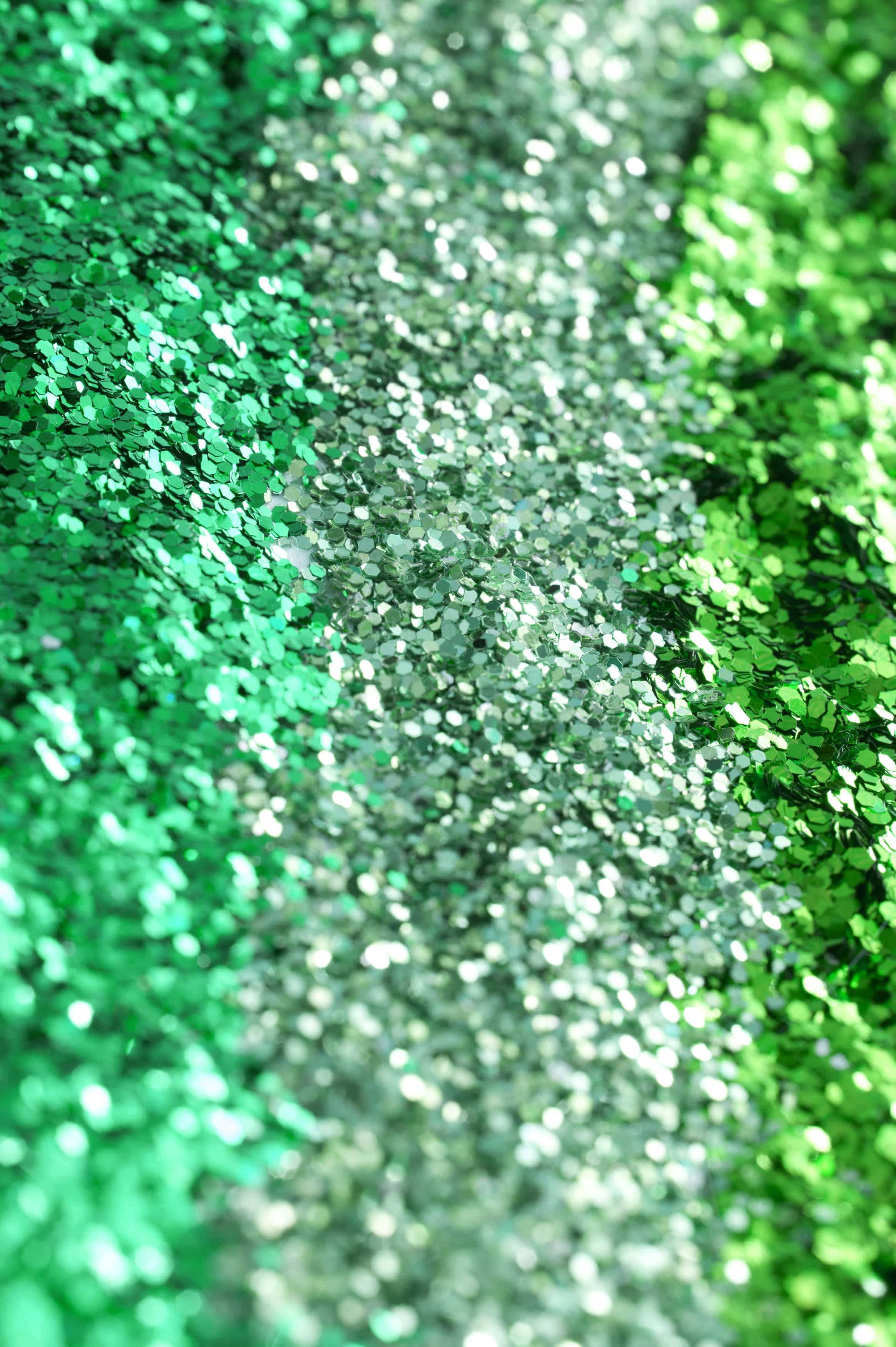 Green Glitter 桌布 壁紙 — 閃爍綠色和銀色亮粉的特寫，帶有模糊的對角漸變效果。
