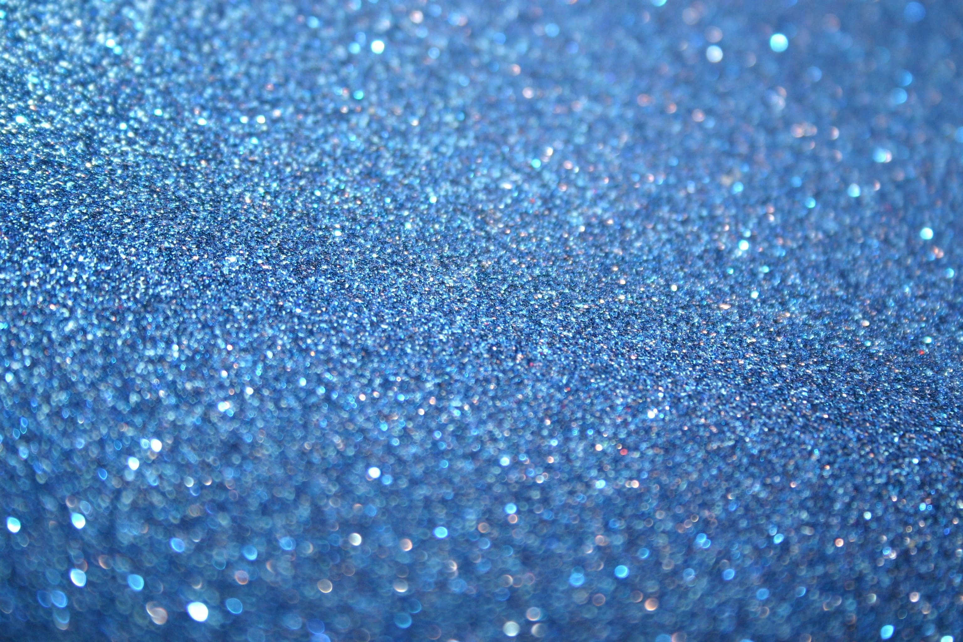 Blue Glitter 桌布 壁紙 — 閃爍藍色亮粉的特寫，帶有閃亮高光和柔和散景效果。