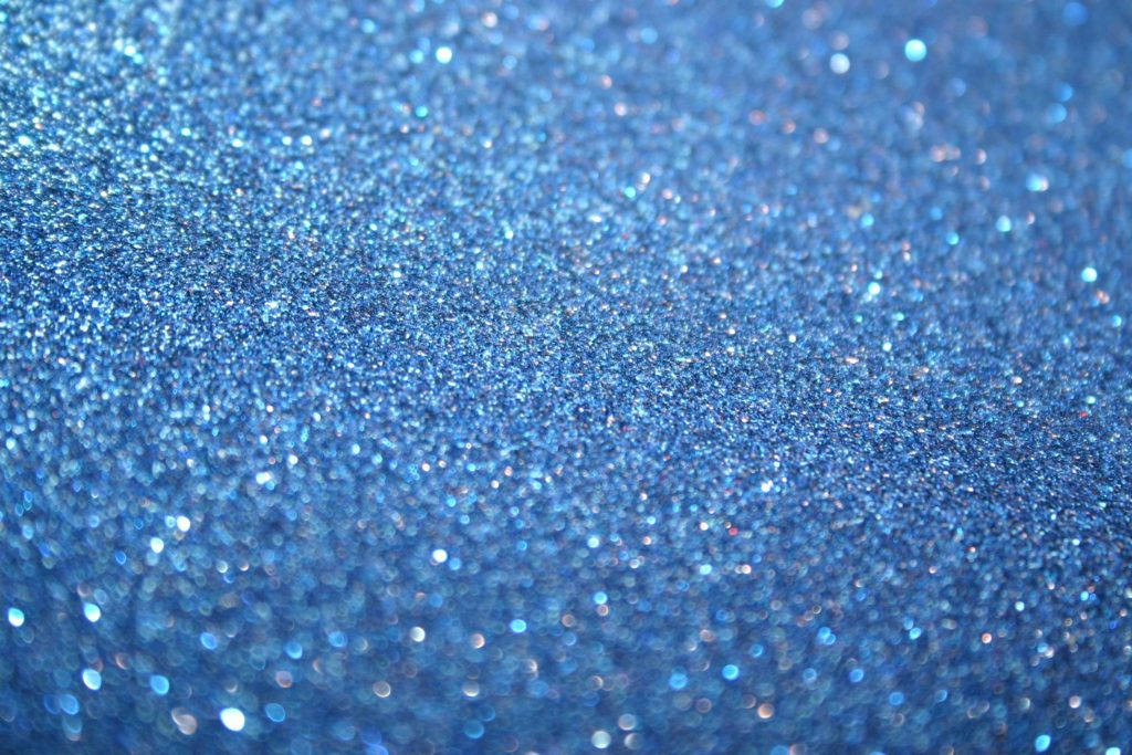 Blue Glitter 桌布 壁紙 — 閃爍藍色亮粉的特寫，帶有閃亮高光和柔和散景效果。