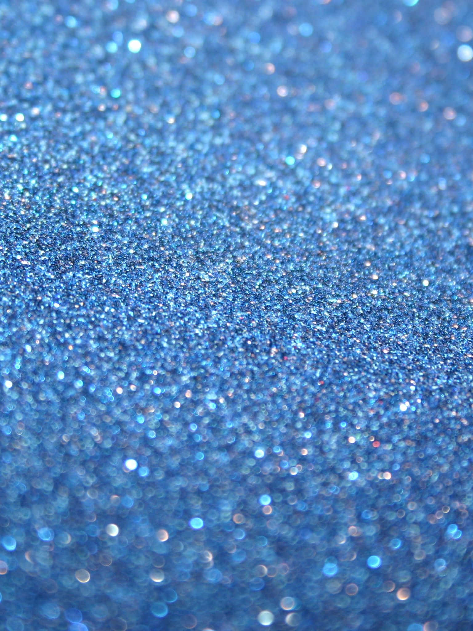 Blue Sparkle 桌布 壁紙 — 閃爍藍色亮粉的特寫，帶有閃亮高光和柔和散景效果。