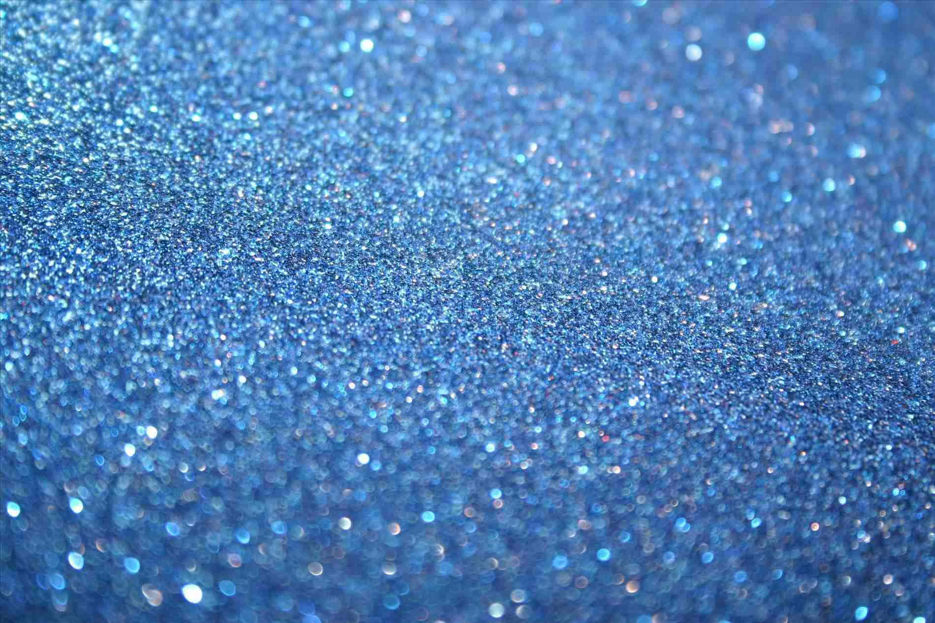 Blue Pastel 桌布 壁紙 — 閃爍藍色亮粉的特寫，帶有閃亮高光和柔和散景效果。