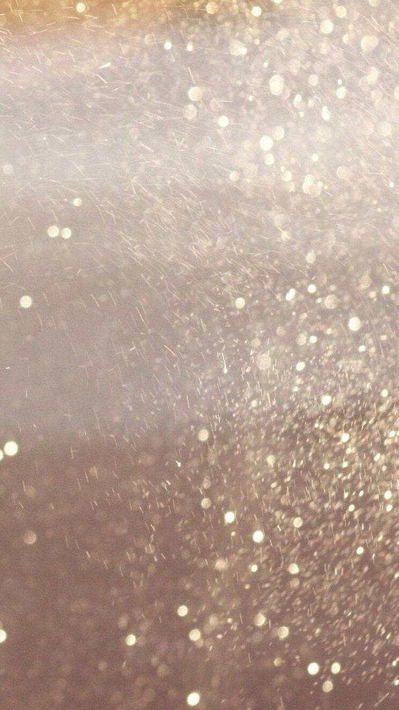 Gold Texture 桌布 壁紙 — 閃爍金色亮片微粒懸浮在柔和光線中的特寫，創造出閃耀的抽象紋理。