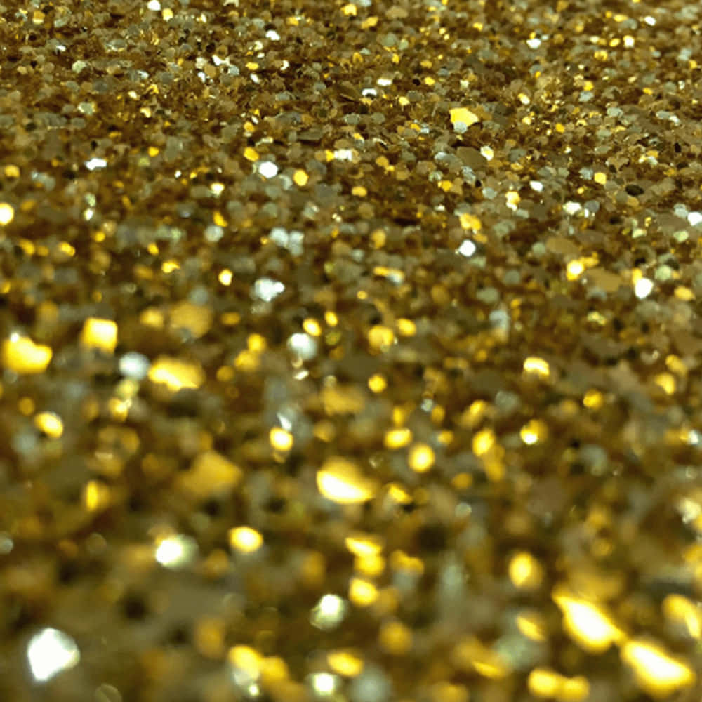 Gold Glitter 桌布 壁紙 — 閃爍金色亮片的特寫，不同大小的顆粒在紋理閃亮表面上捕捉光線。