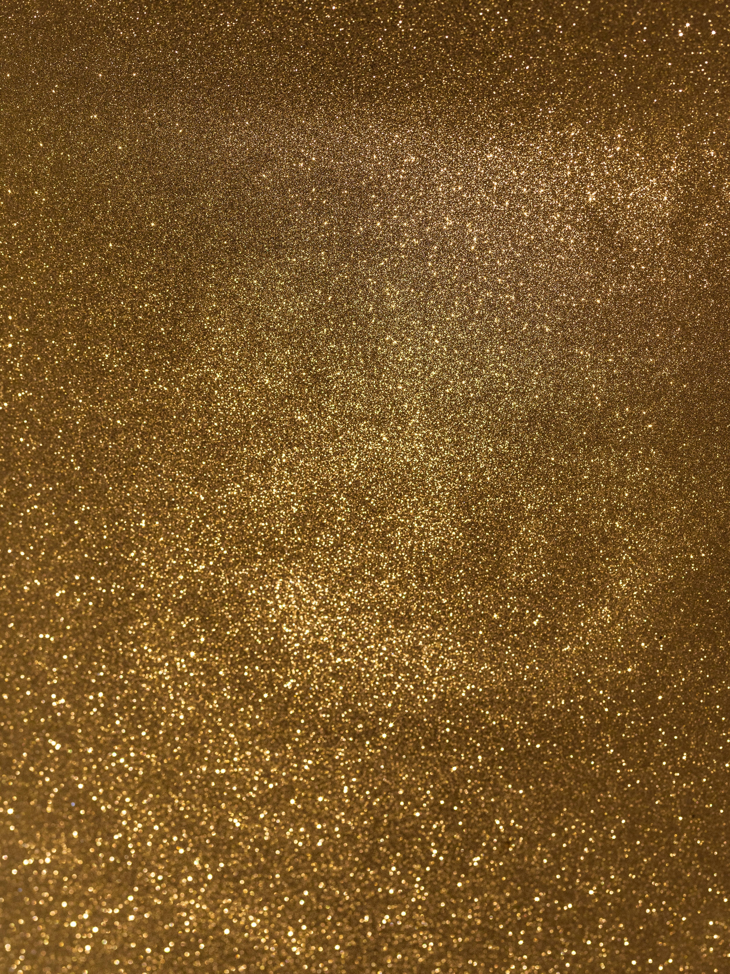 Gold Glitter 桌布 壁紙 — 閃爍金色亮片的特寫，粒子密度變化，營造出豪華的紋理表面。