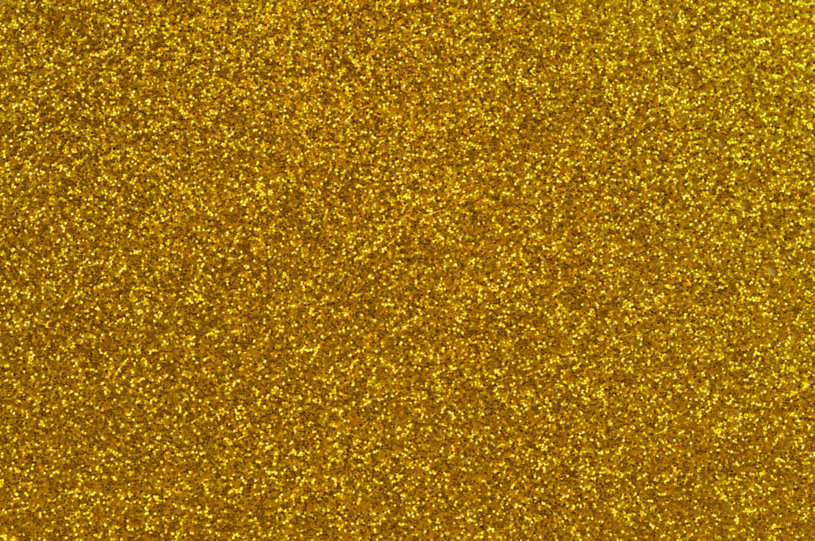Glittery 桌布 壁紙 — 閃爍金色亮片的特寫，閃爍的粒子在整個畫面中捕捉光線。