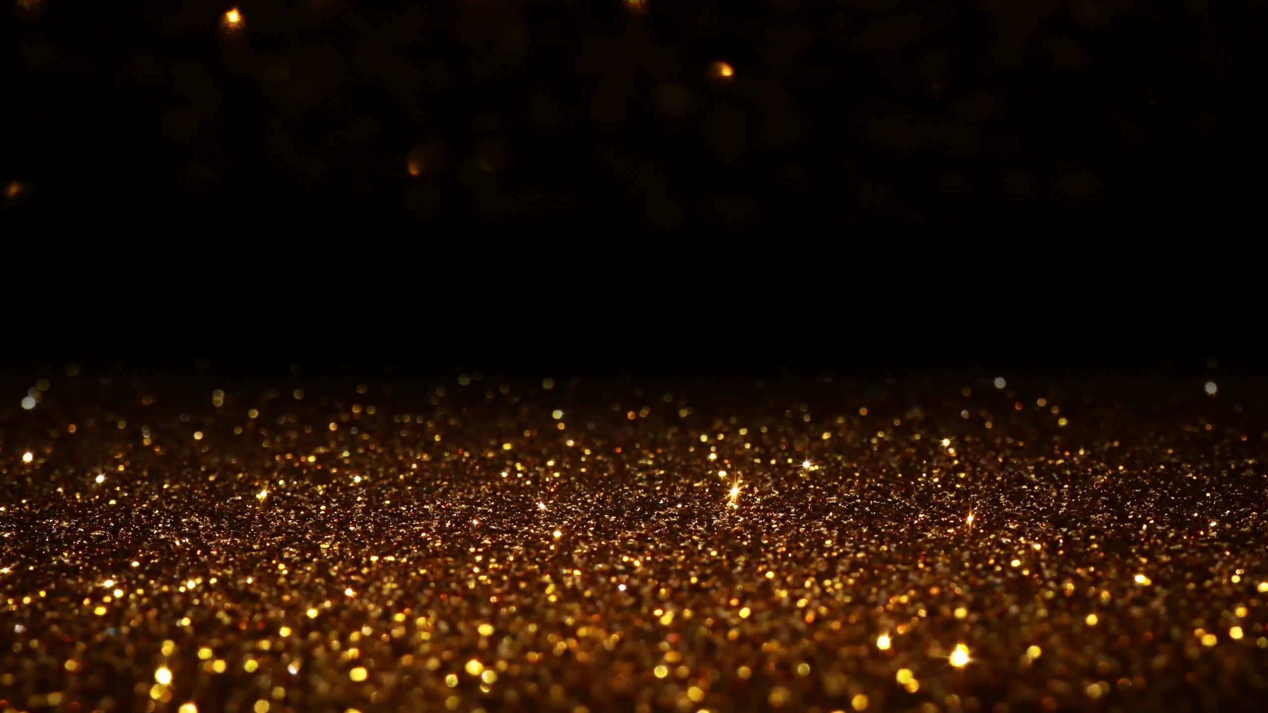 Black And Gold Glitter 桌布 壁紙 — 閃爍金色亮片粒子在深黑色背景上發光的特寫。