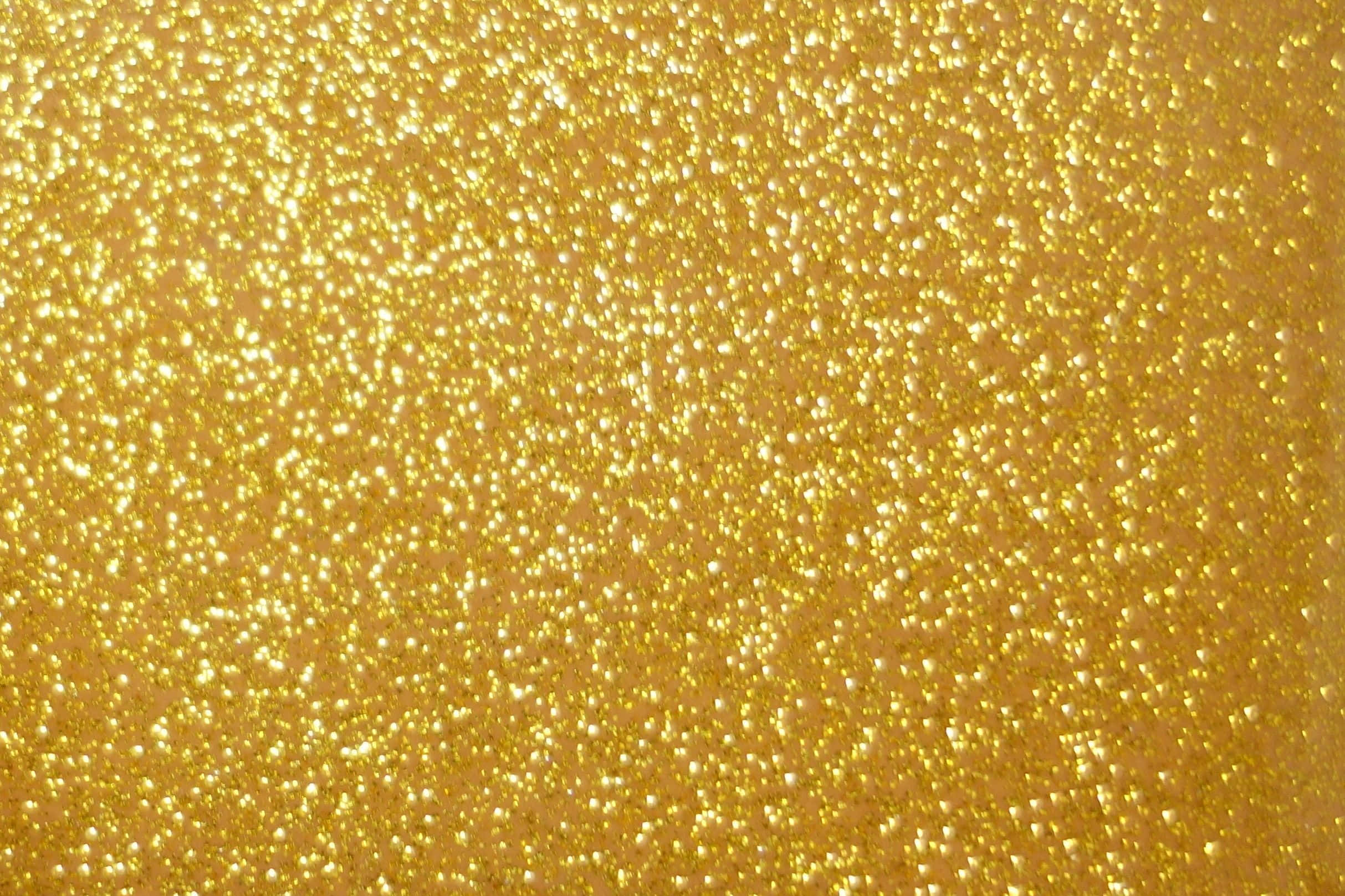 Yellow Glitter 桌布 壁紙 — 閃爍金色亮片顆粒在溫暖金色背景下捕捉光線的特寫。